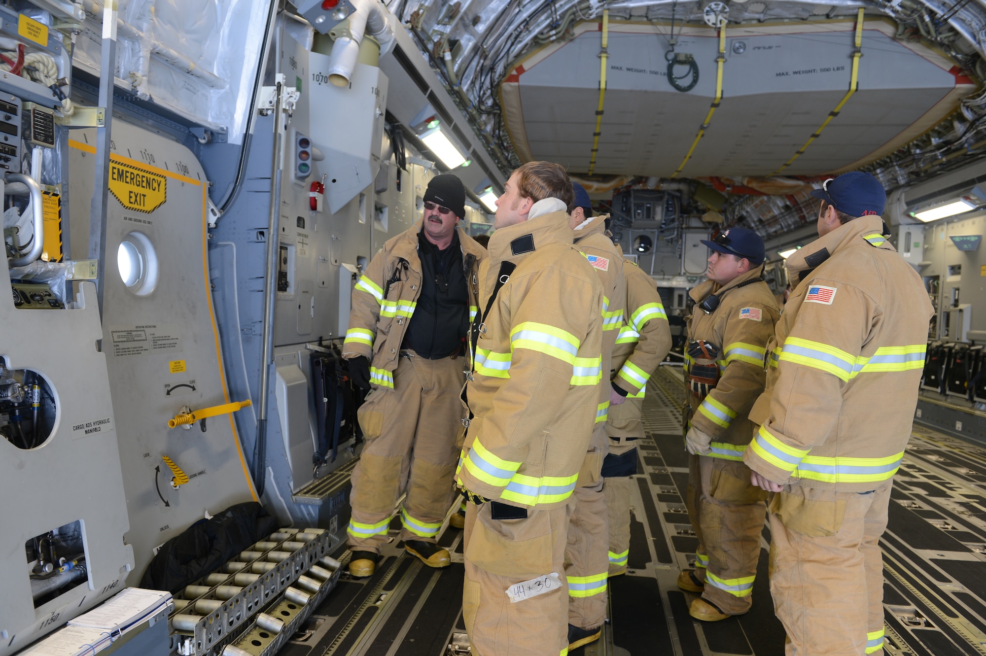McMurdo station firefighters check out one of the exit doors on the McChord Field C-17 Globemaster III aircraft, Oct. 8th, 2014 at the Pegasus White Ice runway, part of McMurdo Station, Antarctica. The firefighters do not get many opportunities to look at all the capabilities of the C-17 and used this chance to get a look at all of its exit points. (U.S. Air Force photo/Master Sgt. Todd Wivell)