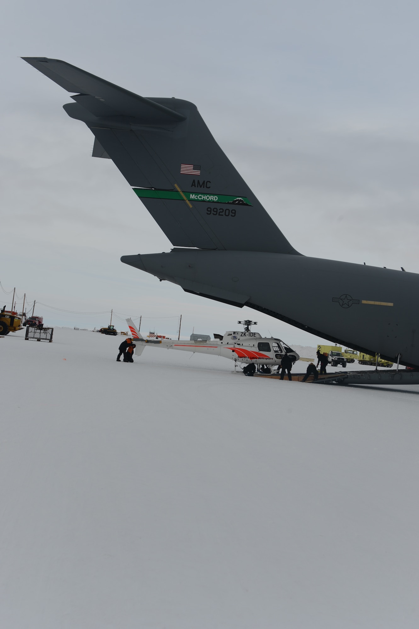 An Eurocopter AS350 B2 single engine helicopter without its blades attached, is offloaded from the back of a McChord Field C-17 Globemaster III aircraft, Oct. 8th, 2014 at the Pegasus White Ice runway, part of McMurdo Station, Antarctica. The helicopter’s blades were attached and it took off before the C-17 departed the station. (U.S. Air Force photo/Master Sgt. Todd Wivell)