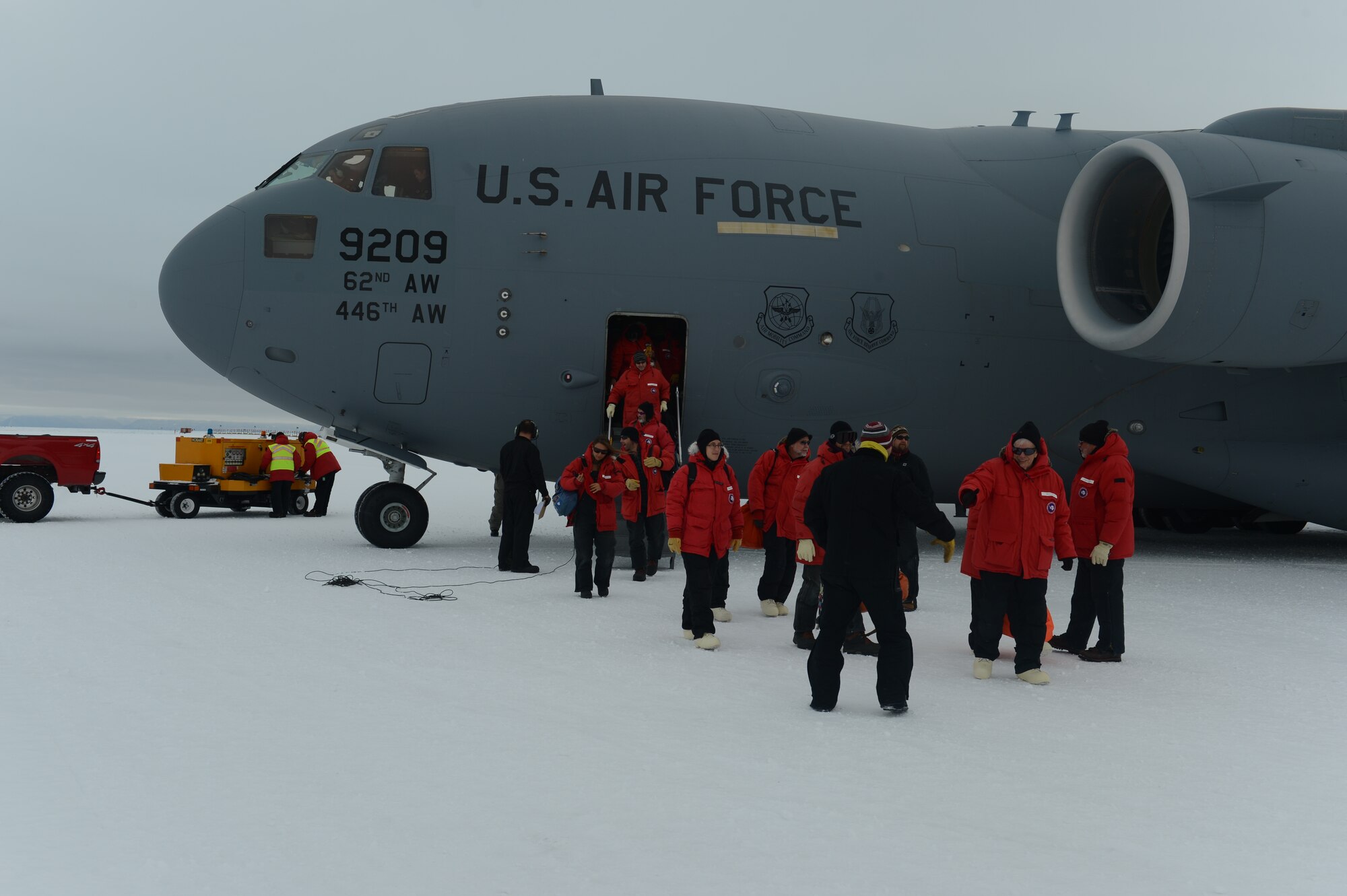 Passengers depart the C-17 Globemaster III aircraft, Oct. 8th, 2014 after landing at the Pegasus White Ice runway, part of McMurdo Station, Antarctica. More than 60 passengers were on board this flight which included a helicopter as part of the cargo. (U.S. Air Force photo/Master Sgt. Todd Wivell)