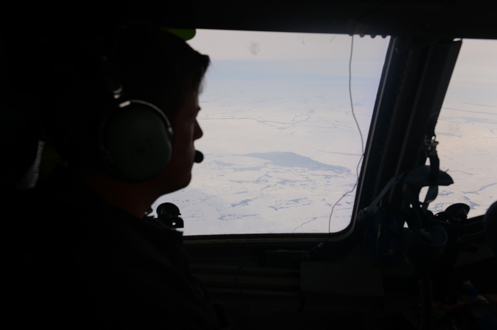 Maj. Jared Wood, 304th Expeditionary Airlift Squadron and 313th Airlift Squadron pilot looks out the window of the McChord Field C-17 Globemaster III aircraft prior to landing, Oct. 8th, 2014 at the Pegasus White Ice runway, part of McMurdo Station, Antarctica. The crew of pilots and loadmasters was made up of members from the 62nd and 446th Airlift Wings. (U.S. Air Force photo/Master Sgt. Todd Wivell)