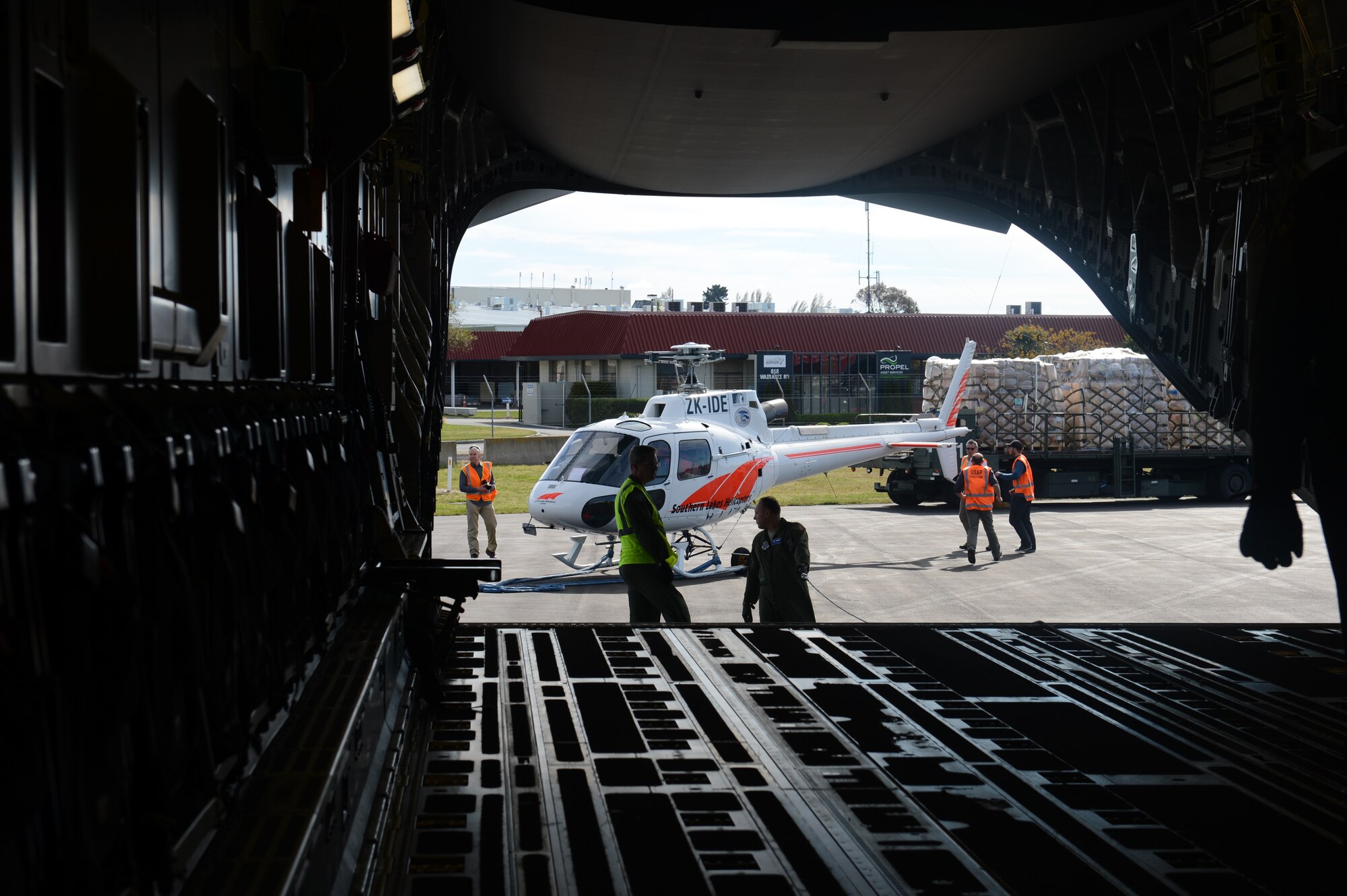 An Eurocopter AS350 B2 single engine helicopter without its blades attached, along with pallets of cargo are staged behind a McChord Field C-17 Globemaster III aircraft prior to being loaded, Oct. 8th, 2014 at Christchurch, New Zealand. The helicopter was transported along with the cargo and 62 passengers to McMurdo Station, Antarctica in support of Operation DEEP FREEZE. (U.S. Air Force photo/Master Sgt. Todd Wivell)