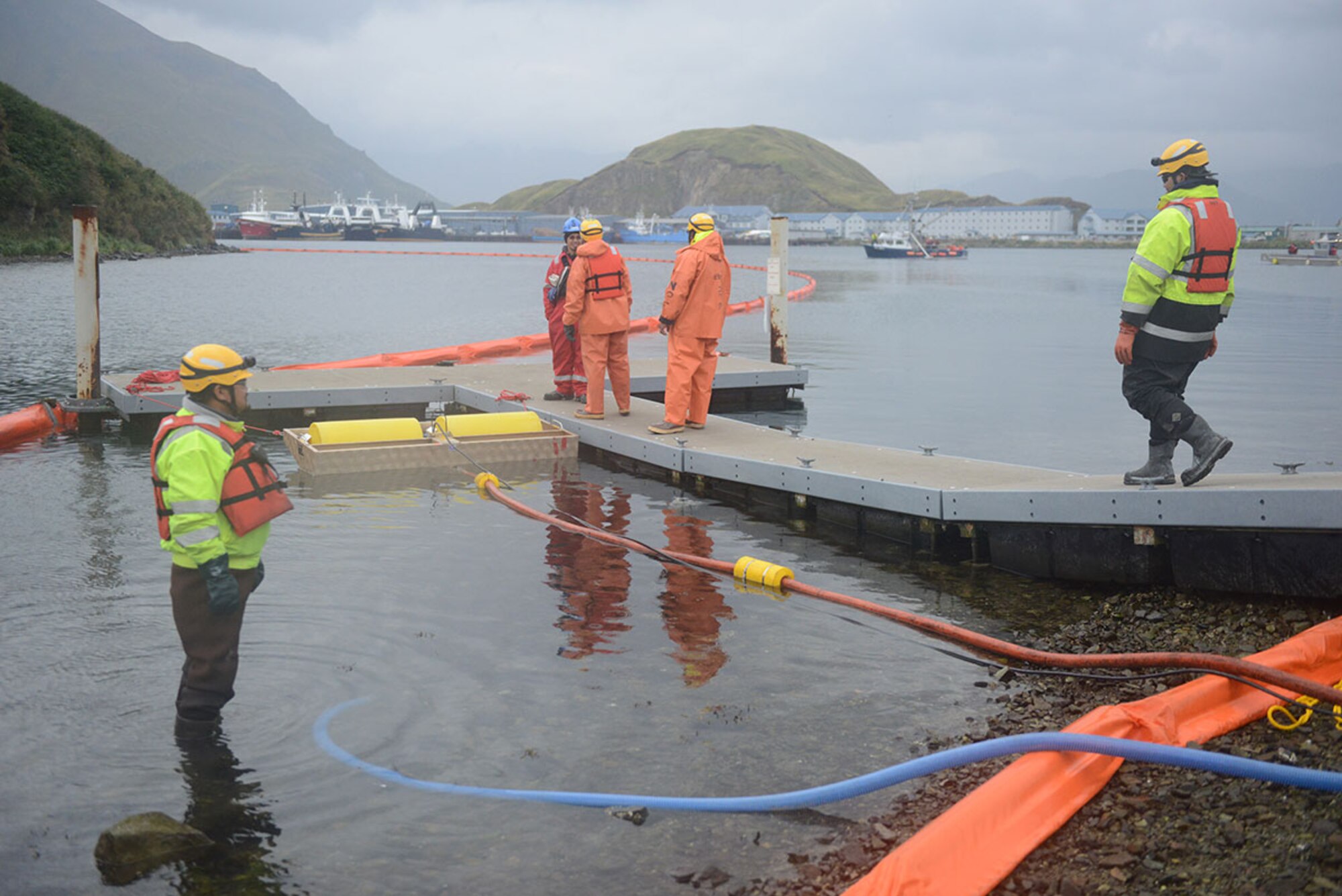 Personnel from North Pacific Fuel deploy boom and a shoreside skimming unit at the entrance to the Iliuliuk River while an Alaska Chadux Corporation vessel operates a Vessel of Opportunity Skimming System during the Aleutians PREP Exercise in Unalaska, Alaska, Sept. 25, 2014. Responders need to train with equipment regularly in order to prepare for the event of a pollution spill. (U.S. Coast Guard photo by Petty Officer 1st Class Shawn Eggert)