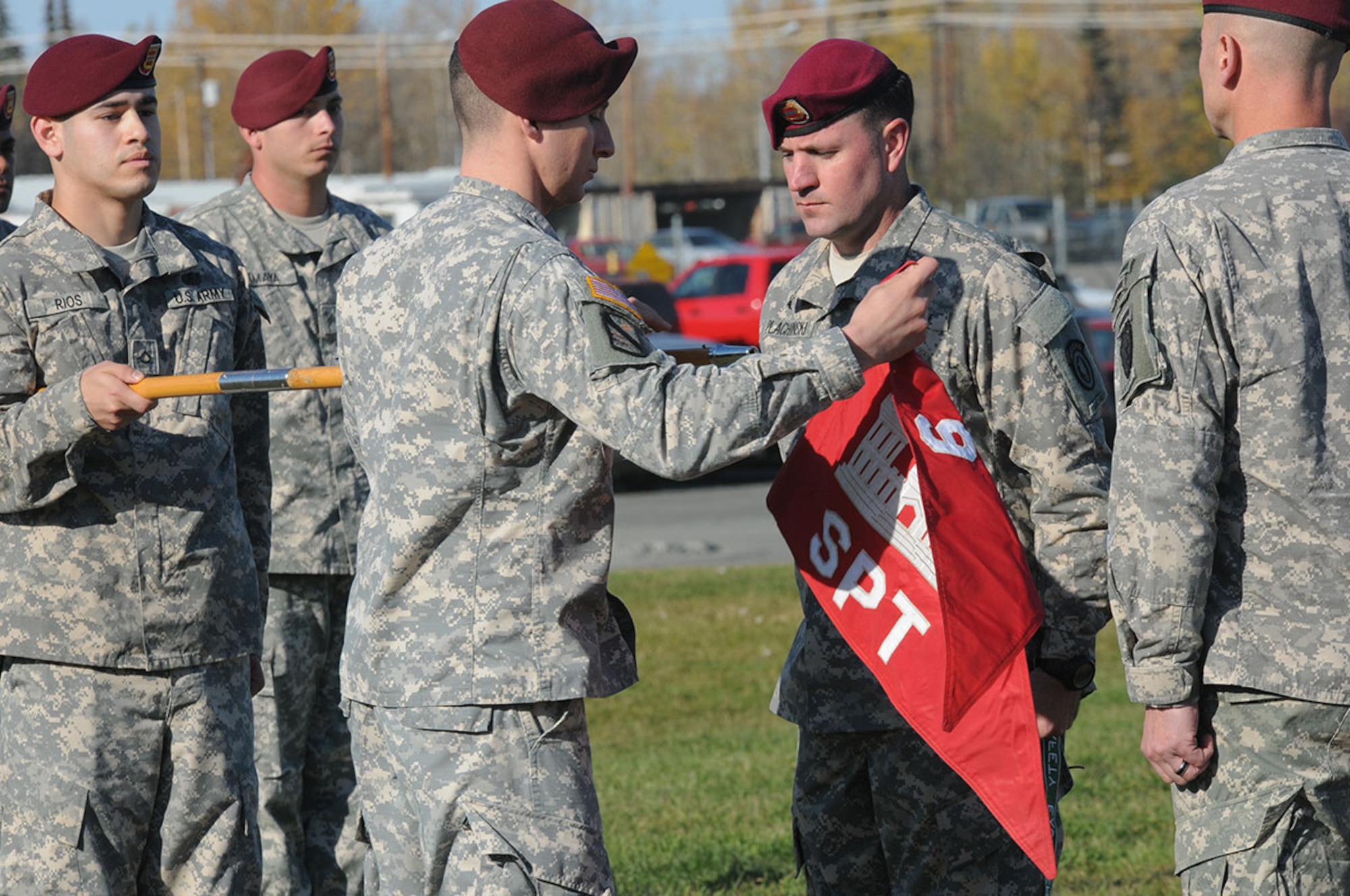 Army Capt. Avraham Behar, commander of the newly instituted forward support company, Echo Company, [attached to the  425th Brigade Special Troops Battalion (Airborne)], 725th Brigade Support Battalion (Airborne), removes the company’s former guidon during the unit’s re-flagging ceremony Oct.1 at Joint Base Elmendorf-Richardson, (U.S. Army photo/Sgt. 1st Class Jeffrey Smith)