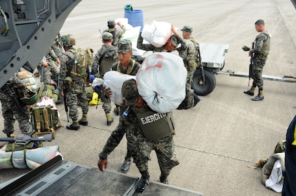Honduran service members load bags of supplies onto a U.S. Army CH-47F Chinook October 8 during Operation Caravana.  Operation Caravana’s sole purpose is to provide the Honduran military freedom of movement and access to the isolated areas in Gracias a Dios, Colon and Olancho in order to continue their security operations.  These troop movements and logistics re-supply flights will occur on an as-needed basis.  (Photo by U.S. Air National Guard Capt. Steven Stubbs)