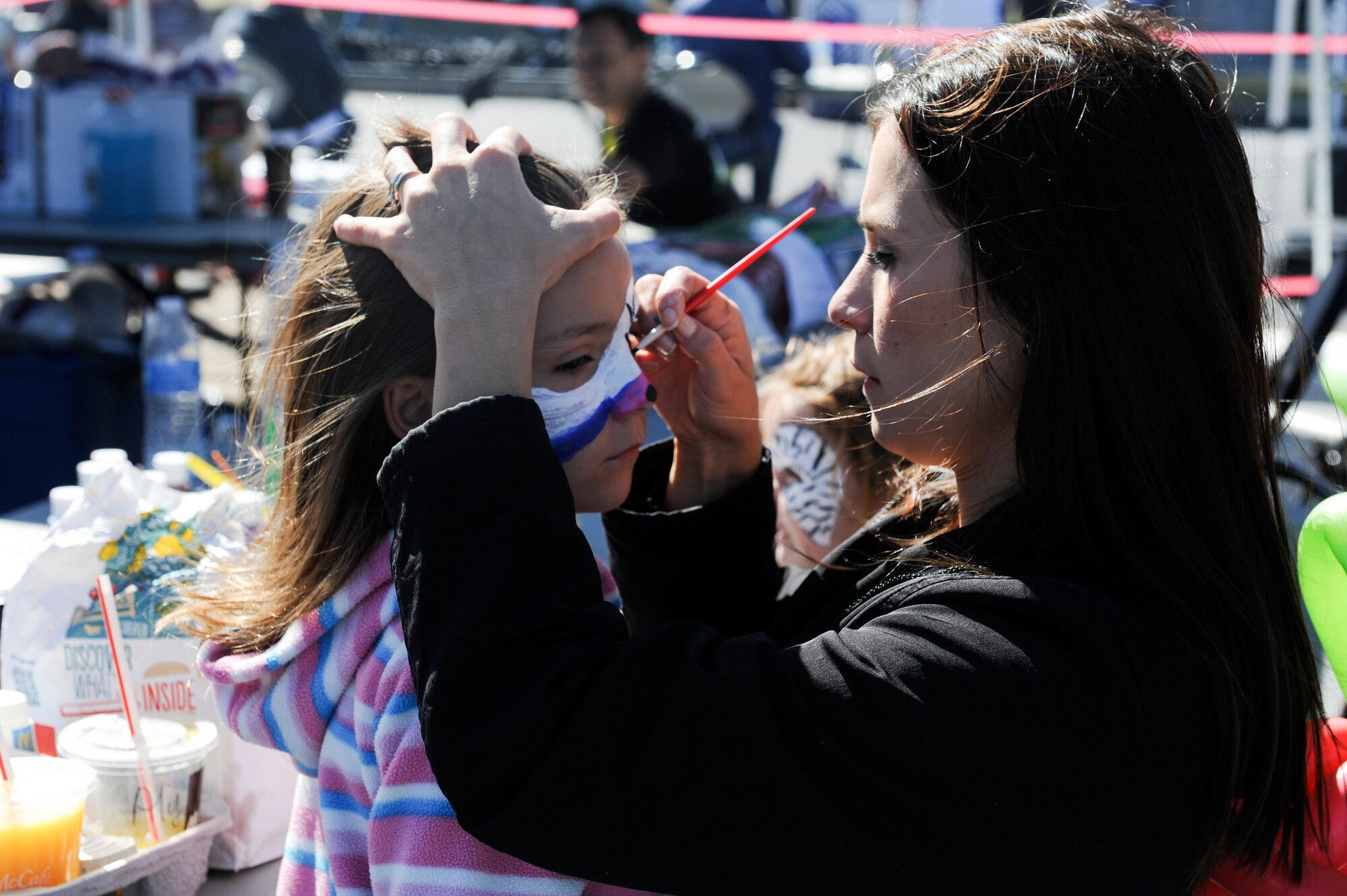 Summer McCall paints her daughter's face during Rocktoberfest Oct. 4, 2014, at Little Rock Air Force Base, Ark. A face painting booth was one of many activitiesTeam Little Rock families had during the event. (U.S. Air Force photo by Staff Sgt. Jessica Condit)