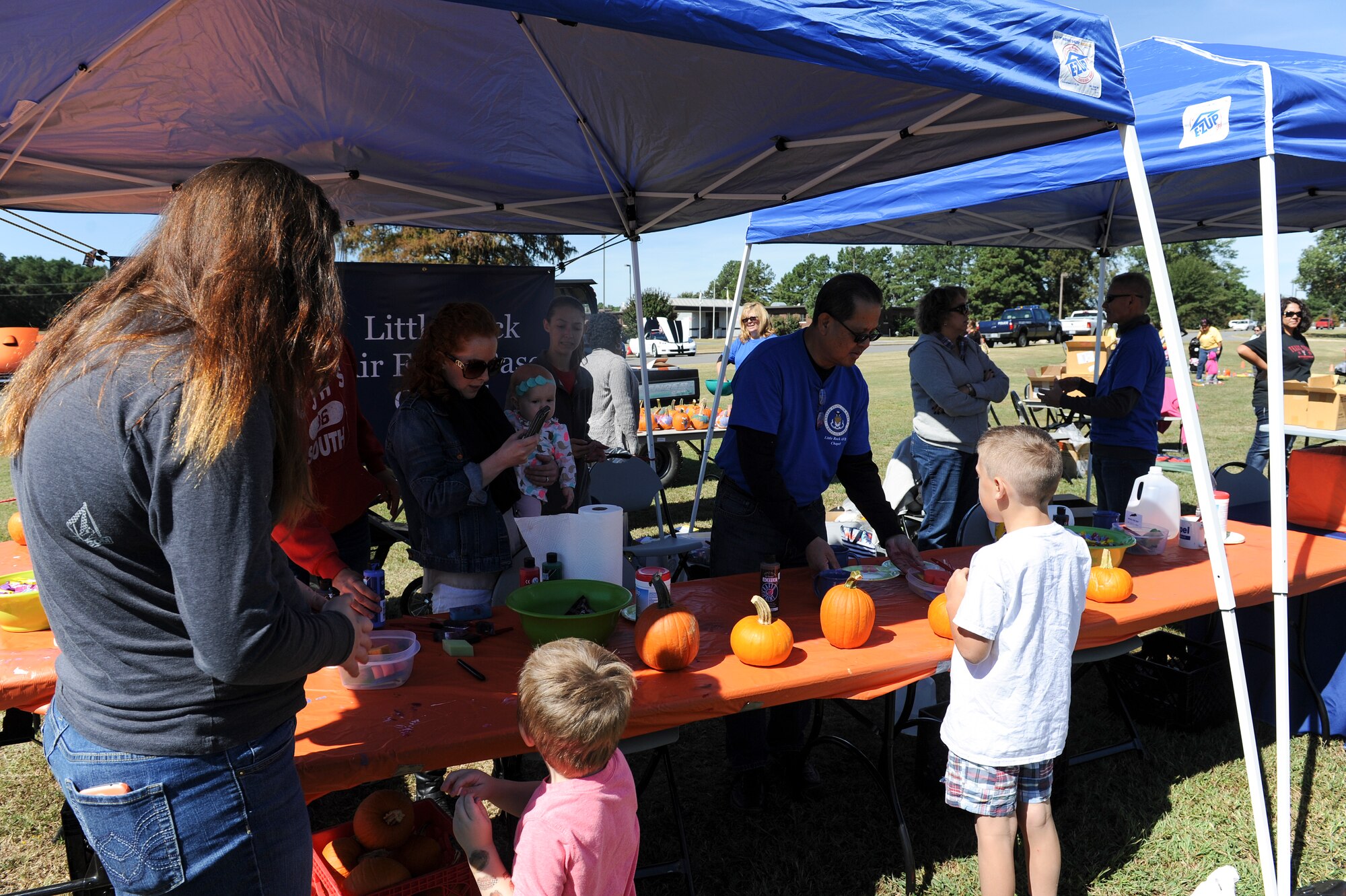 Rocktoberfest attendees paint miniature pumpkins at a tent hosted by the base chapel Oct. 4, 2014, at Little Rock Air Force Base, Ark. The base chapel provided nearly 200 pumpkins for children to paint during Rocktoberfest. (U.S. Air Force photo by Staff Sgt. Jessica Condit)