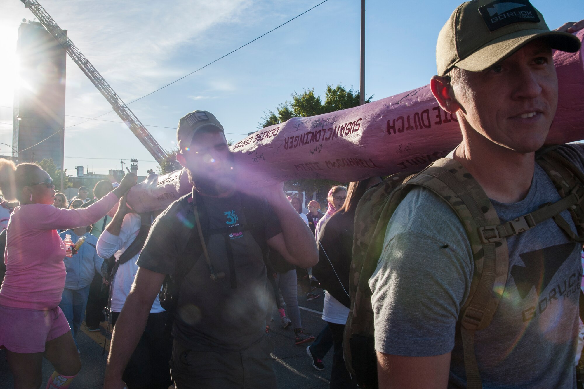 Race participants carry a log representing a token of hope for their grandmother, who is fighting breast cancer Oct. 4, 2014, in downtown Little Rock, Ark. Crowds of supporters lined the streets to cheer on the walkers and runners during the race. (U.S. Air Force photo by Senior Airman Kaylee Clark)