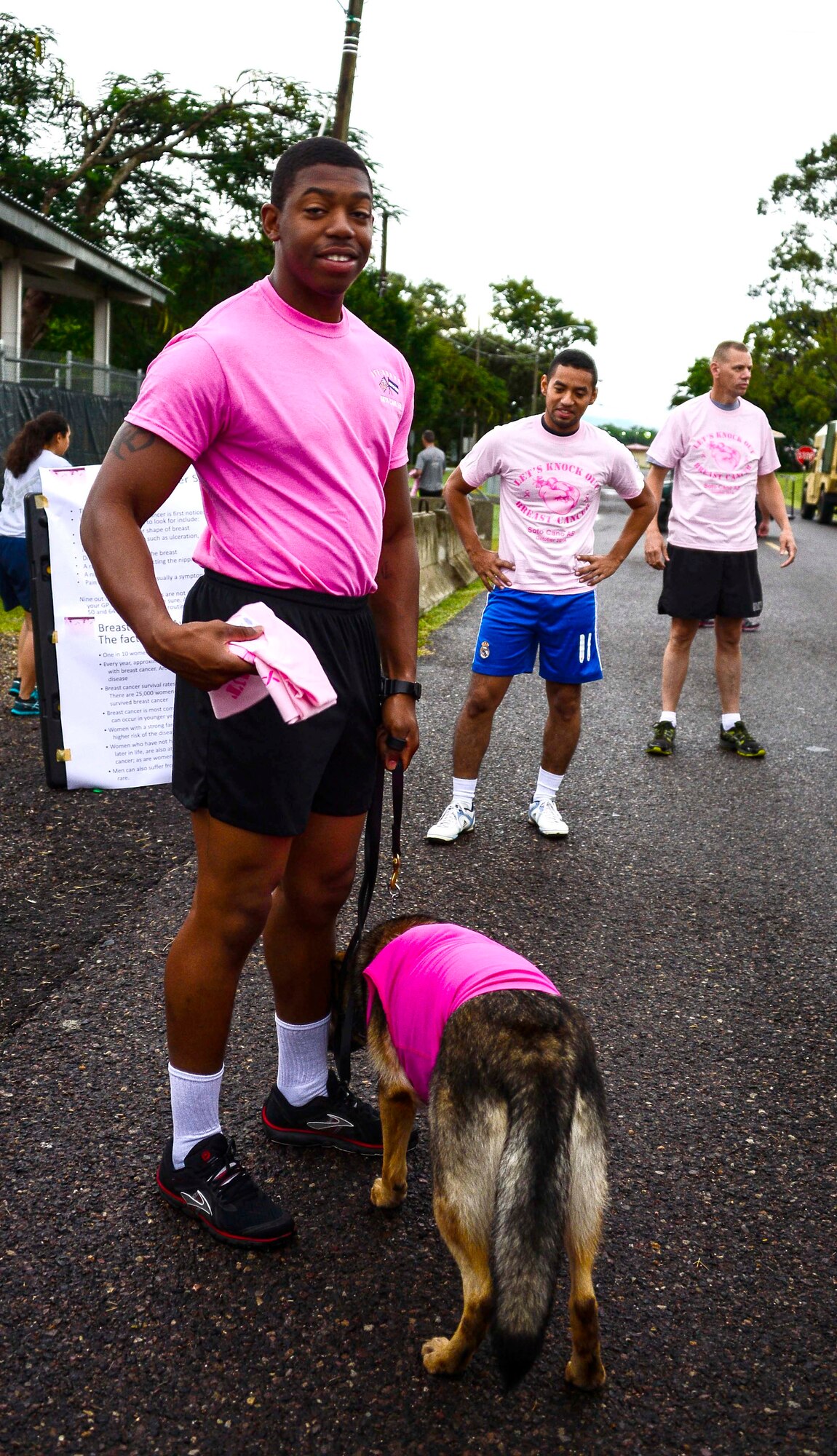 Military Working Dog handler U.S. Army Spc. Bruce Brickleff with his partner Jaska dress in pink for the “Think Pink 5K” supporting Breast Cancer Awareness on Soto Cano Air Base, Oct. 9, 2014.   The fun run was planned and coordinated by the Morale, Welfare, and Recreation Center to help increase breast cancer awareness. (U.S. Air Force photo by Tech. Sgt. Heather R. Redman/Released)