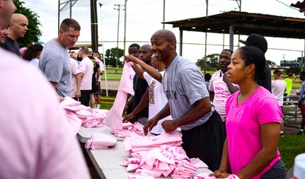 Volunteers from Joint Task Force-Bravo hand out pink shirts for the “Think Pink 5K” supporting Breast Cancer Awareness on Soto Cano Air Base, Oct. 9, 2014.   The fun run was planned and coordinated by the Morale, Welfare, and Recreation Center to help increase breast cancer awareness. (U.S. Air Force photo by Tech. Sgt. Heather R. Redman/Released)