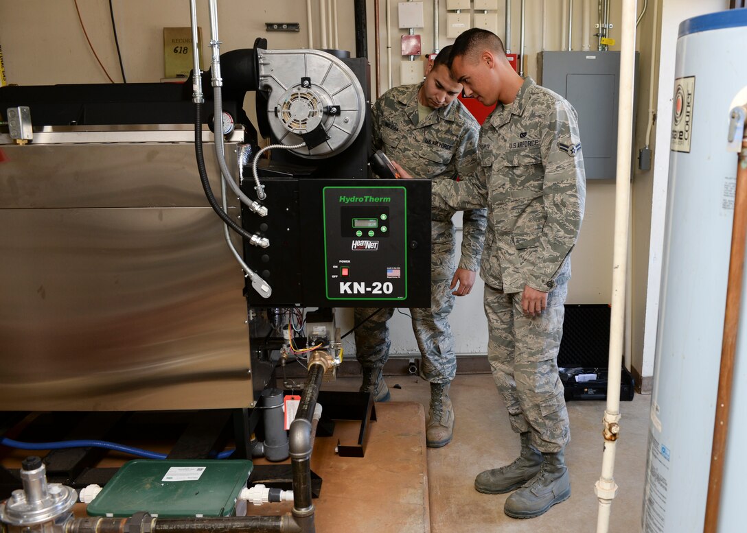 Airman 1st Class Zane Zeitler and Staff Sgt. Jose Hinojosa, 28th Civil Engineer Squadron heating, ventilation and air conditioning repair technicians, analyze combustion efficiency levels on a HydroTherm Boiler at Ellsworth Air Force Base, S.D., Oct. 8, 2014. The HydroTherm boiler is one of 70 boilers that have been installed in facilities throughout the base that modulates water temperatures in relation to outdoor weather temperatures reducing energy output by more than 20 percent. (U.S. Air Force photo by Senior Airman Anania Tekurio/Released)