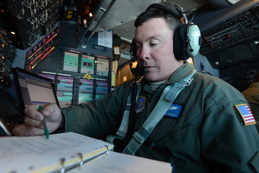 Master Sgt. Pete Unkrur, a C-5M Super Galaxy flight engineer from the 436th Airlift Wing reviews a checklist while running aircraft system checks at his station during a mission to Warner-Robins Air Force Base, Ga. Unkrur and crew are on a mission to retrieve a Lockheed C-60 Lodestar during a crew proficiency and unusual-load training mission Oct. 5, 2014.  The C-5M was flown by a crew from the 9th Airlift Squadron. Loading assistance and expertise on the C-60 was provided by a team from the Air Mobility Command Museum. (U.S. Air Force photo/Greg L. Davis)