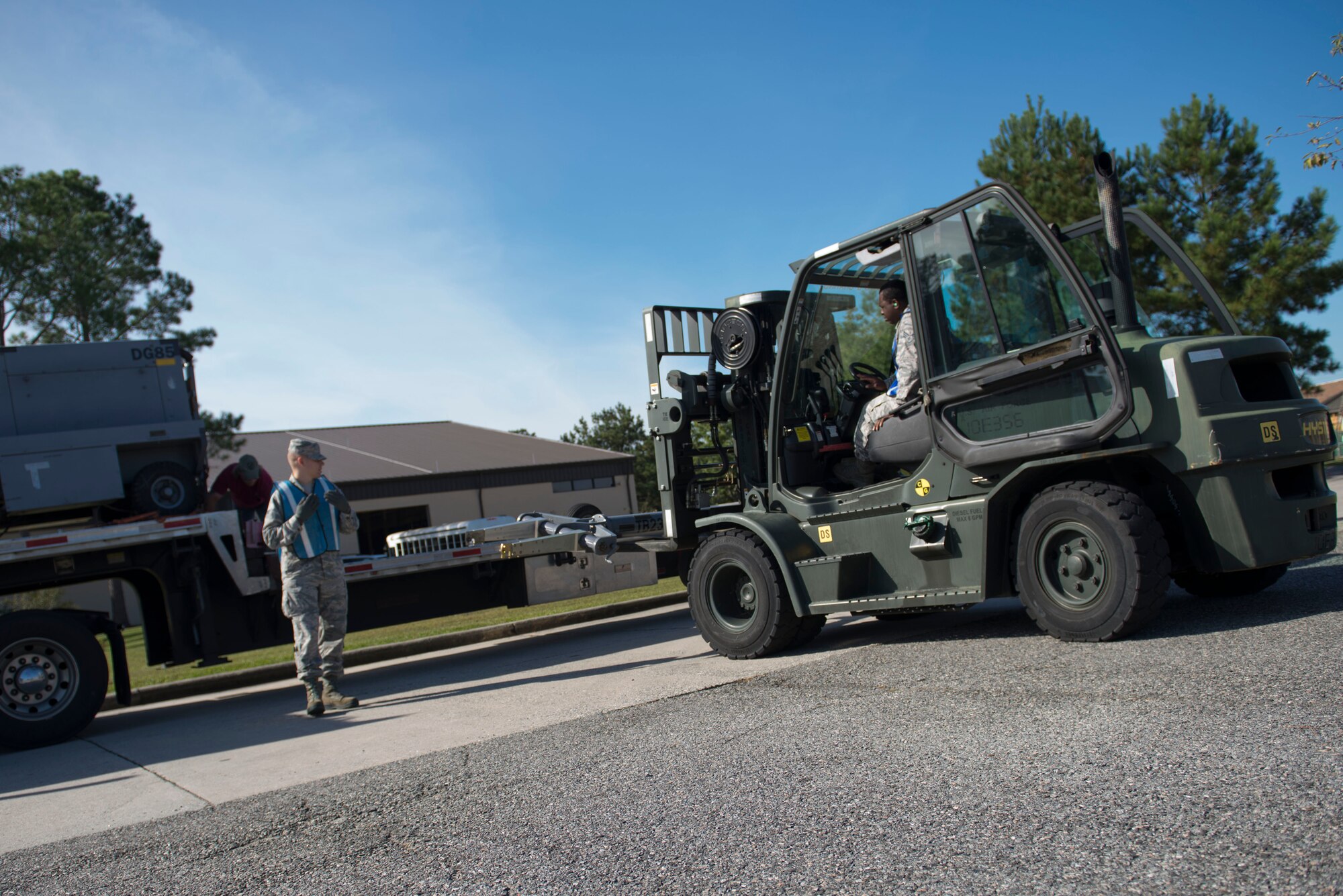U.S. Air Force Senior Airman Jarvaris Hicks, right, 23d Civil Engineer Squadron heavy equipment journeyman, and Airman 1st Class Matthew Busen, 23d Logistics Readiness Squadron load team member, load essential cargo for a Wing Readiness Inspection Oct. 7, 2014, at Moody Air Force Base, Ga. Logistics Airmen shipped the cargo for a simulated contingency deployment to Avon Park Air Force Range, Fla. (U.S. Air Force photo by Airman 1st Class Dillian Bamman/Released)