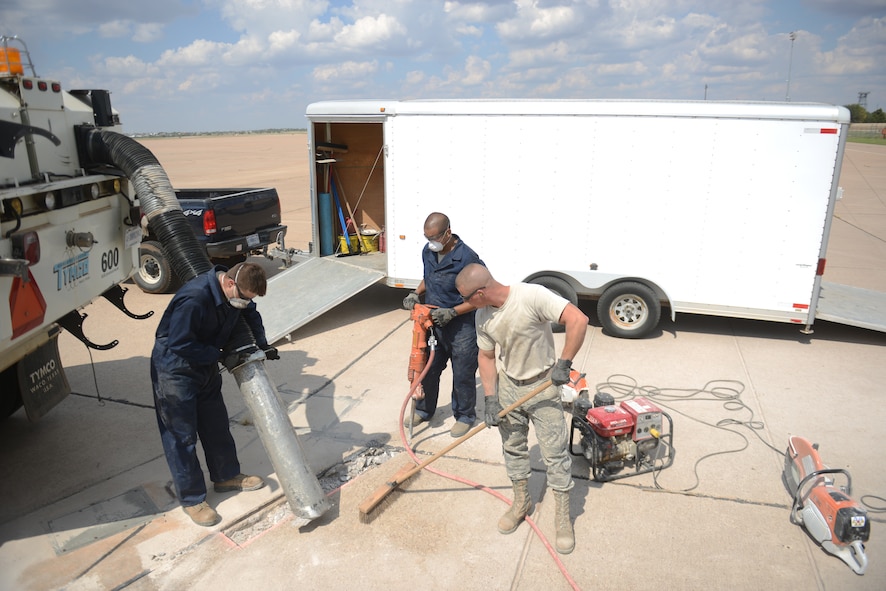 U.S. Air Force Airmen, from the 7th Civil Engineer Squadron, repair concrete on the flight line Sept. 29, 2014, at Dyess Air Force Base, Texas. By repairing concrete on the airfield, it helps prevent damage to aircraft and further damage to the airfield pavement. (U.S. Air Force photo by Airman 1st Class Kedesha Pennant/Released)