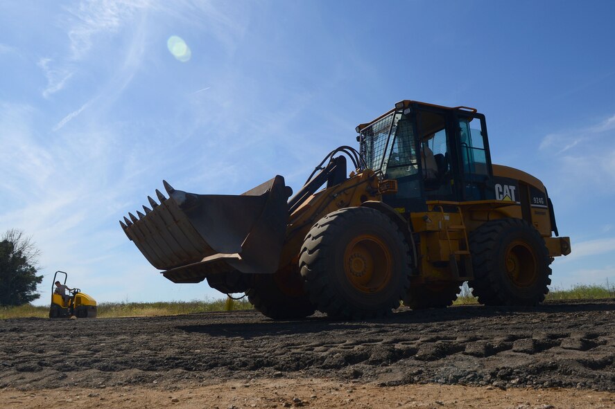 Airmen from the 20th Civil Engineer Squadron lay asphalt for cars to park in one of the running trail areas at Shaw Air Force Base, S.C., Oct. 9, 2014. The asphalt is from the remains of Perimeter Road, a creative and cost efficient way to beautify the installation. (U.S. Air Force photo by Senior Airman Ashley L. Gardner/Released)

