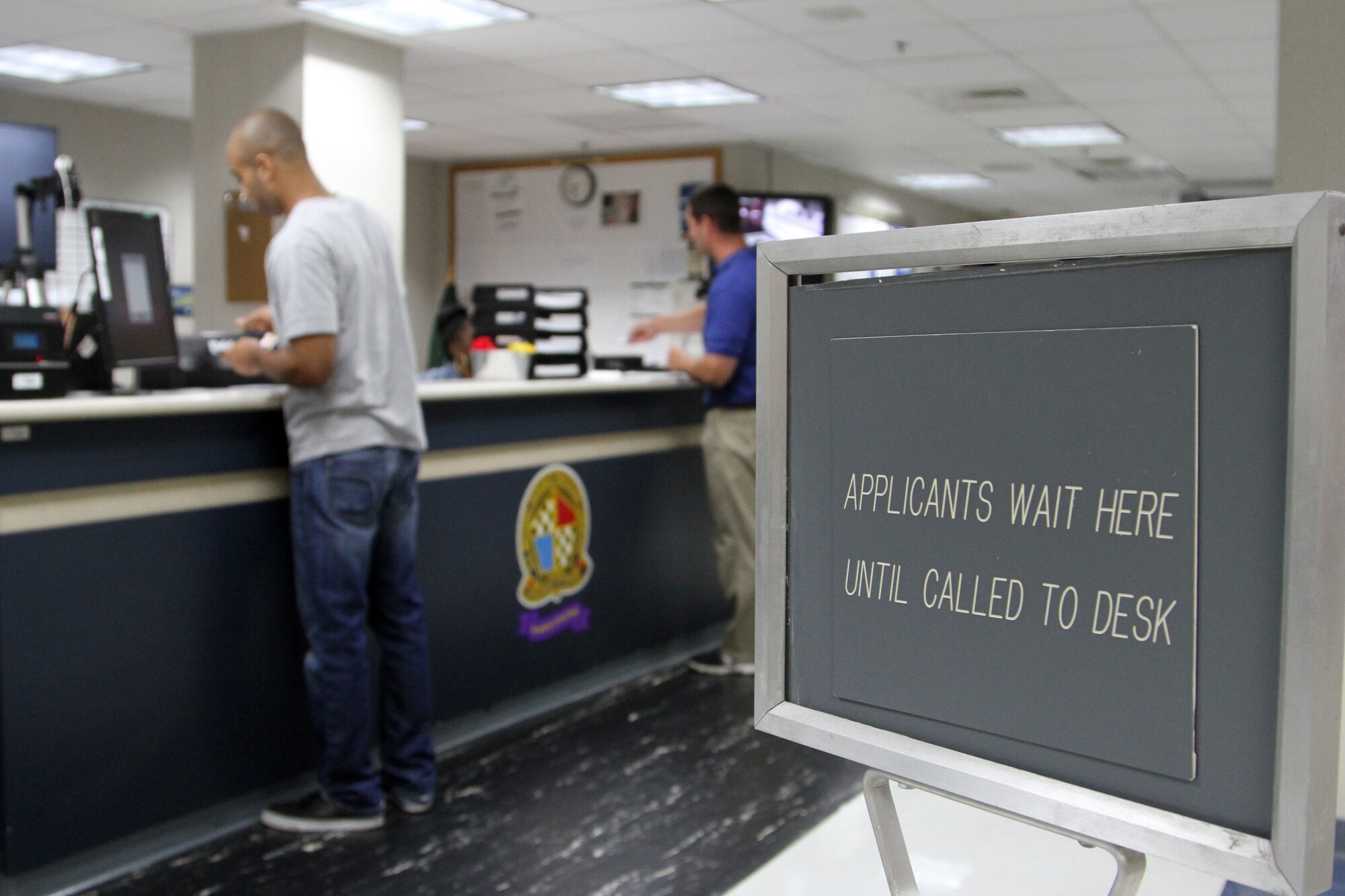 Applicants collect there paperwork after confirming there identifications and taking pictures at the central command desk while inprocessing at the Military Entrance Processing Station on Joint Base McGuire-Dix-Lakehurst, N.J., Oct. 7, 2014. (U.S. Army photo by Sgt. Richard W. Hoppe/Released)