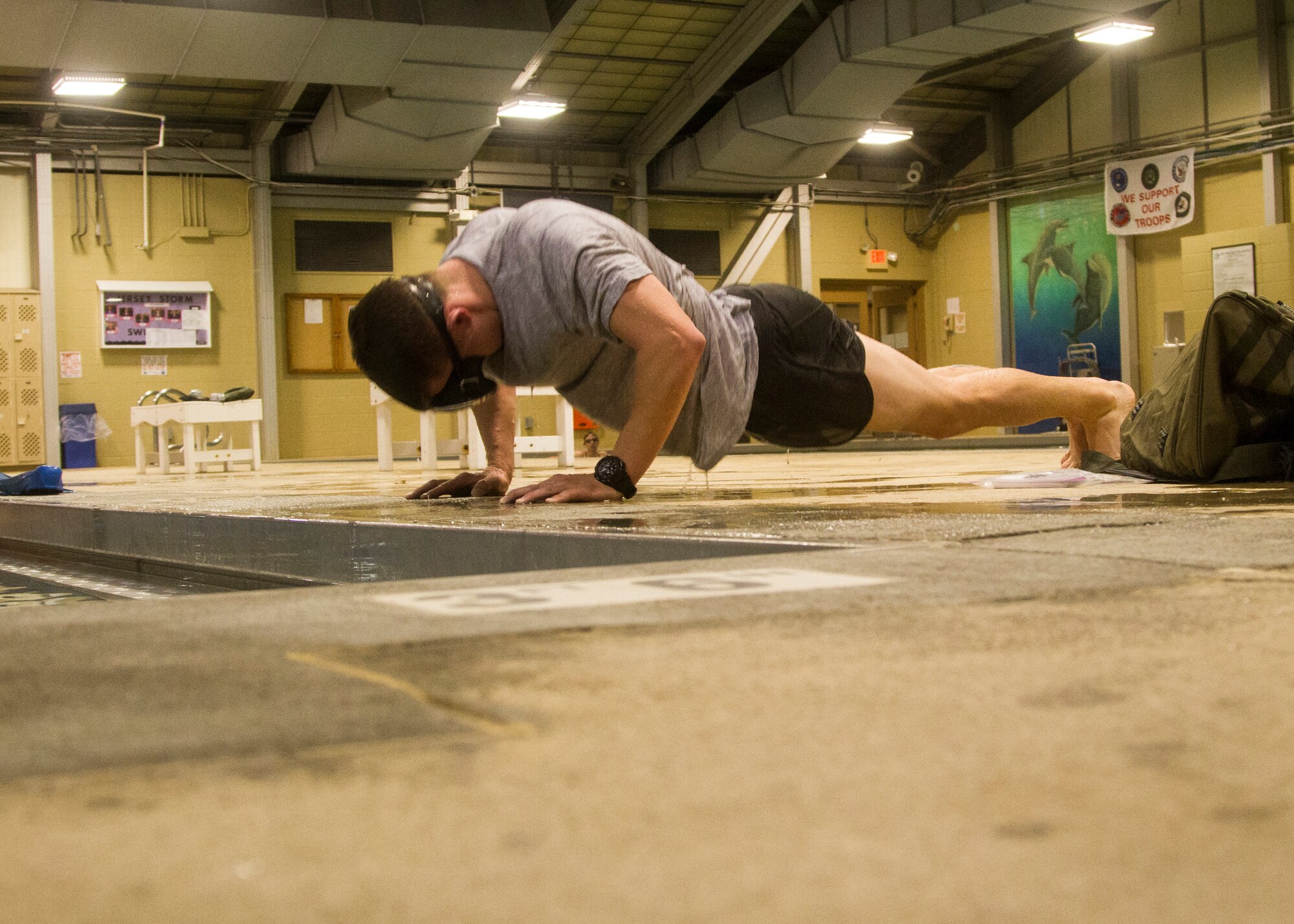 Airman 1st Class Jordan Robinson, a cyber systems operator with the 87th Communication Squadron, performs pushups between sets of 200-meter laps in the indoor pool at Joint Base McGuire-Dix-Lakehurst, N.J., Oct. 7, 2014. Robinson exercises here daily in preparation to attend the selection phase of Air Force Combat Controller School. (Photo by U.S. Army Sgt. Ryan Scott/Released)