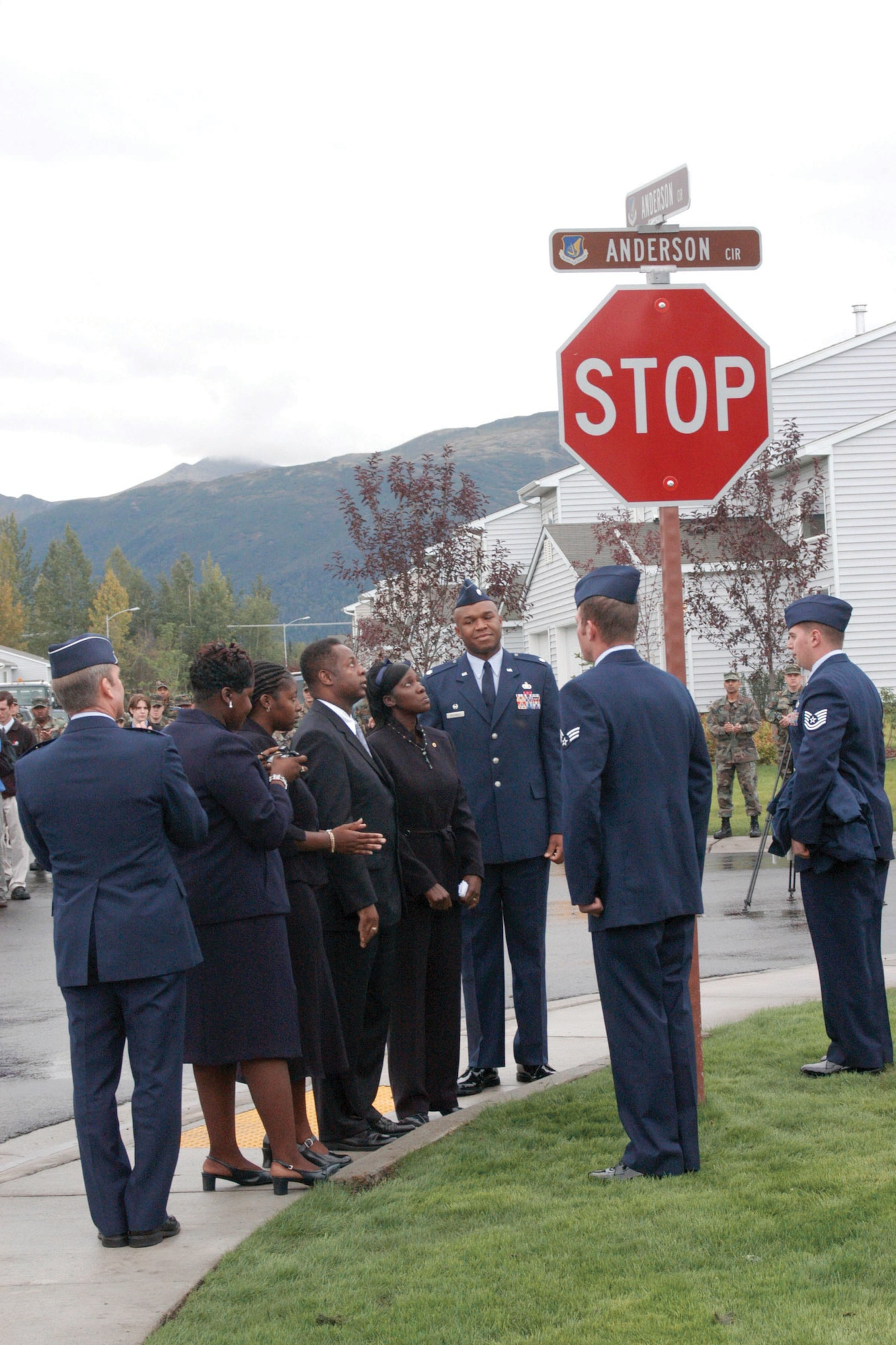 The family of Airman 1st Class Carl Anderson Jr. looks at the sign that declares the corner they’re standing on Anderson Circle. On the left of the family is Brig. Gen. Herbert J. Carlisle. Tech. Sgt. Michael Helmick, left foreground, and Senior Airman Jacob Sutton, guarding the sign, were with Anderson when he was killed in Iraq in 2004. (U.S. Air Force photo/Samantha Quigley) 