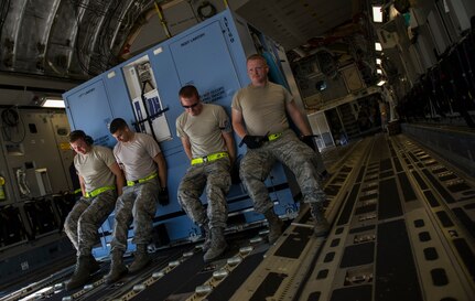 437th Aerial Port Squadron Airmen push cargo onto a C-17 Globemaster III, Oct. 8, 2014, on the flightline at Joint Base Charleston, S.C. In addition to their normal duties of loading and unloading C-17s, the 437th APS provides support for the nation’s premier rapid deployment forces: XVIII Airborne Corps, 82nd Airborne Division, Joint Special Operations Command and the 43rd Airlift Wing. The squadron is prepared to meet short-notice, worldwide mobility taskings in support of national objectives, and plans and executes support for more than 50 percent of all joint airborne and air transportability training missions flown by Air Mobility Command and Reserve forces in support of Joint Operations. (U.S. Air Force photo/Airman 1st Class Clayton Cupit)