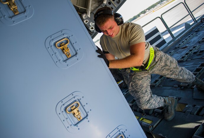 Airman 1st Class Luke Saylors, 437th Aerial Port Squadron air transportation technician, pushes cargo onto a C-17 Globemaster III, Oct. 8, 2014, on the flightline at Joint Base Charleston, S.C. In addition to their normal duties of loading and unloading C-17s, the 437th APS provides support for the nation’s premier rapid deployment forces: XVIII Airborne Corps, 82nd Airborne Division, Joint Special Operations Command and the 43rd Airlift Wing. The squadron is prepared to meet short-notice, worldwide mobility taskings in support of national objectives, and plans and executes support for more than 50 percent of all joint airborne and air transportability training missions flown by Air Mobility Command and Reserve forces in support of Joint Operations. (U.S. Air Force photo/Airman 1st Class Clayton Cupit)