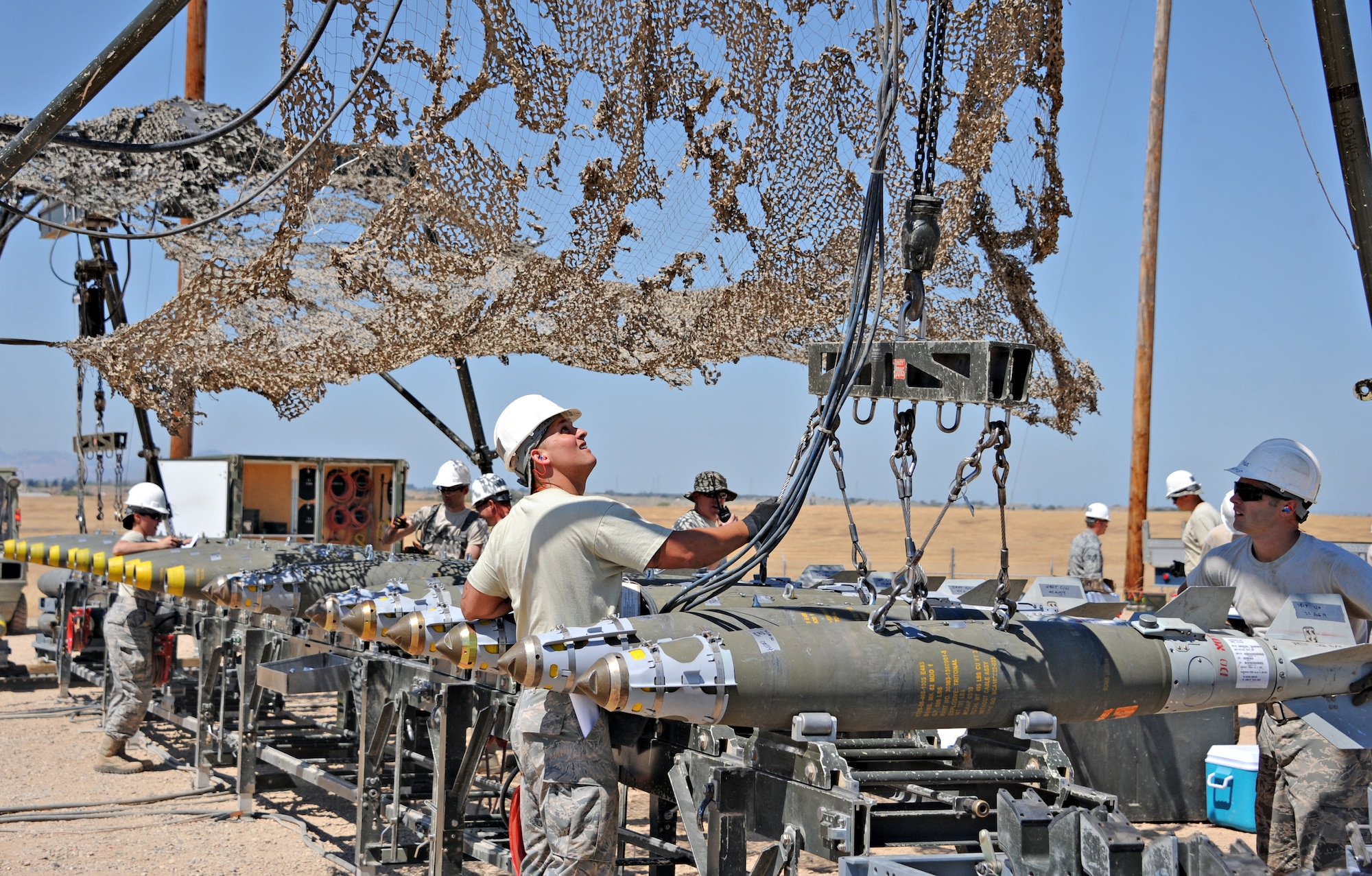 Air Force Combat Ammunition Center students hoist ammunition during the Iron Flag exercise Aug. 22, 2014, at Beale Air Force Base, Calif. AFCOMAC is a school for senior airmen and above as upgrade training to provide the Air Force munitions community with advanced training in mass combat ammunition planning and production techniques. (U.S. Air Force photo by Airman 1st Class Ramon A. Adelan/Released)