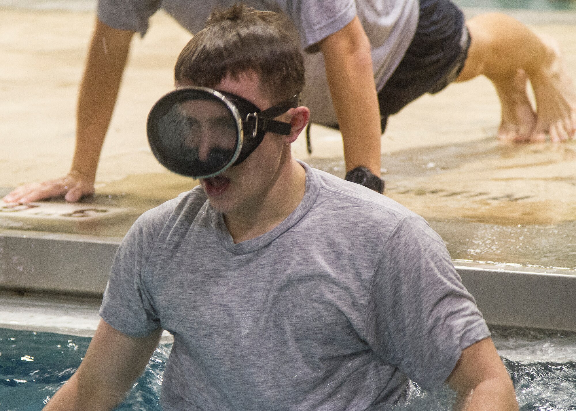Airman 1st Class Jordan Robinson jumps back into the pool after performing pushups between sets of 200-meter laps in the indoor pool at Joint Base McGuire-Dix-Lakehurst, N.J., Oct. 7, 2014. Robinson exercises here daily in preparation to attend the selection phase of Air Force Combat Controller School. (U.S. Army photo by Sgt. Ryan Scott/Released)