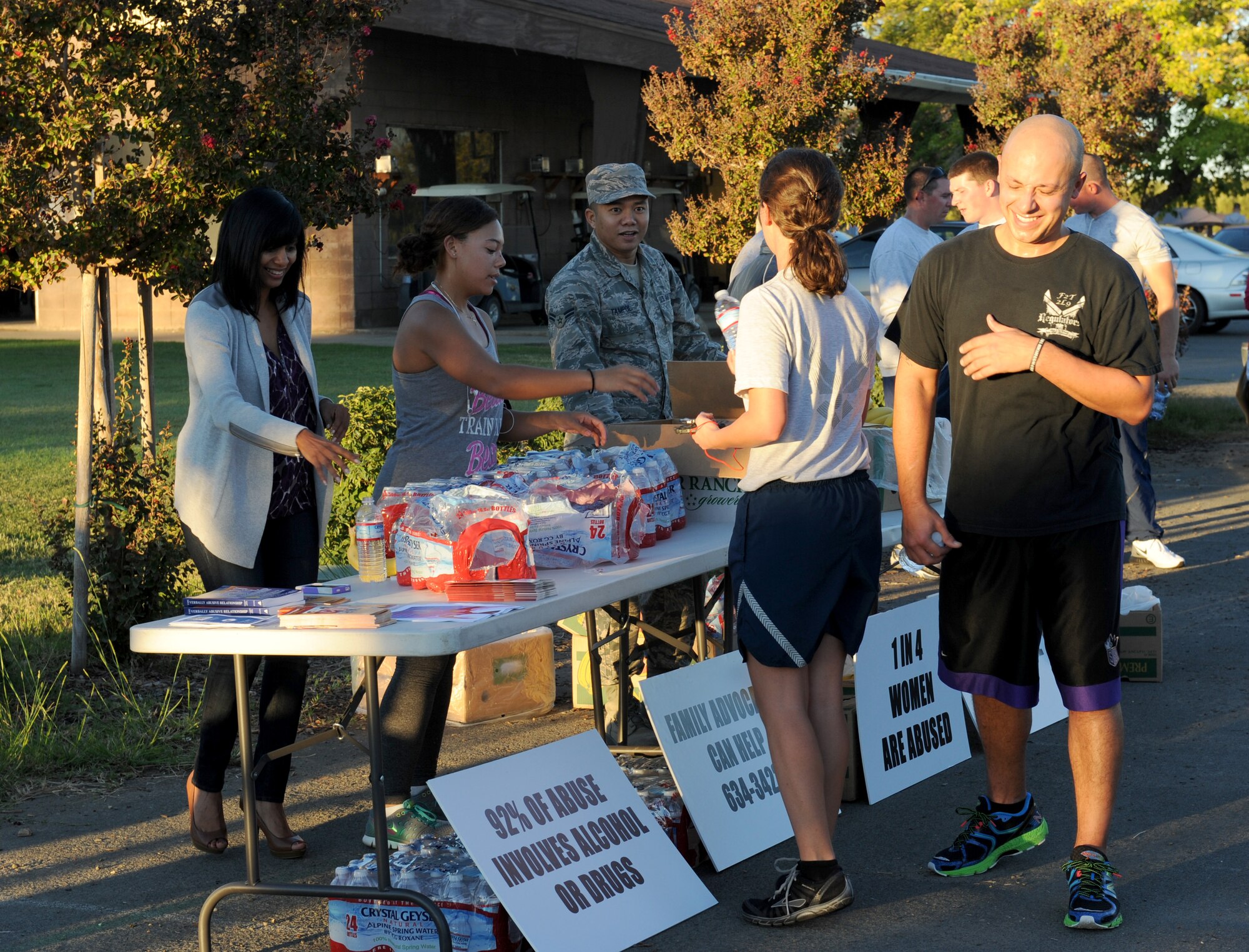 Members of the Family Advocacy office distribute water and fruit during a 5K run to observe Domestic Violence Awareness Month on Beale Air Force Base, Calif., Oct. 8, 2014. October was designated Domestic Violence Awareness Month in 1987 to raise awareness and educate the public on prevention. (U.S. Air Force photo by Staff Sgt. Robert M. Trujillo/Released)