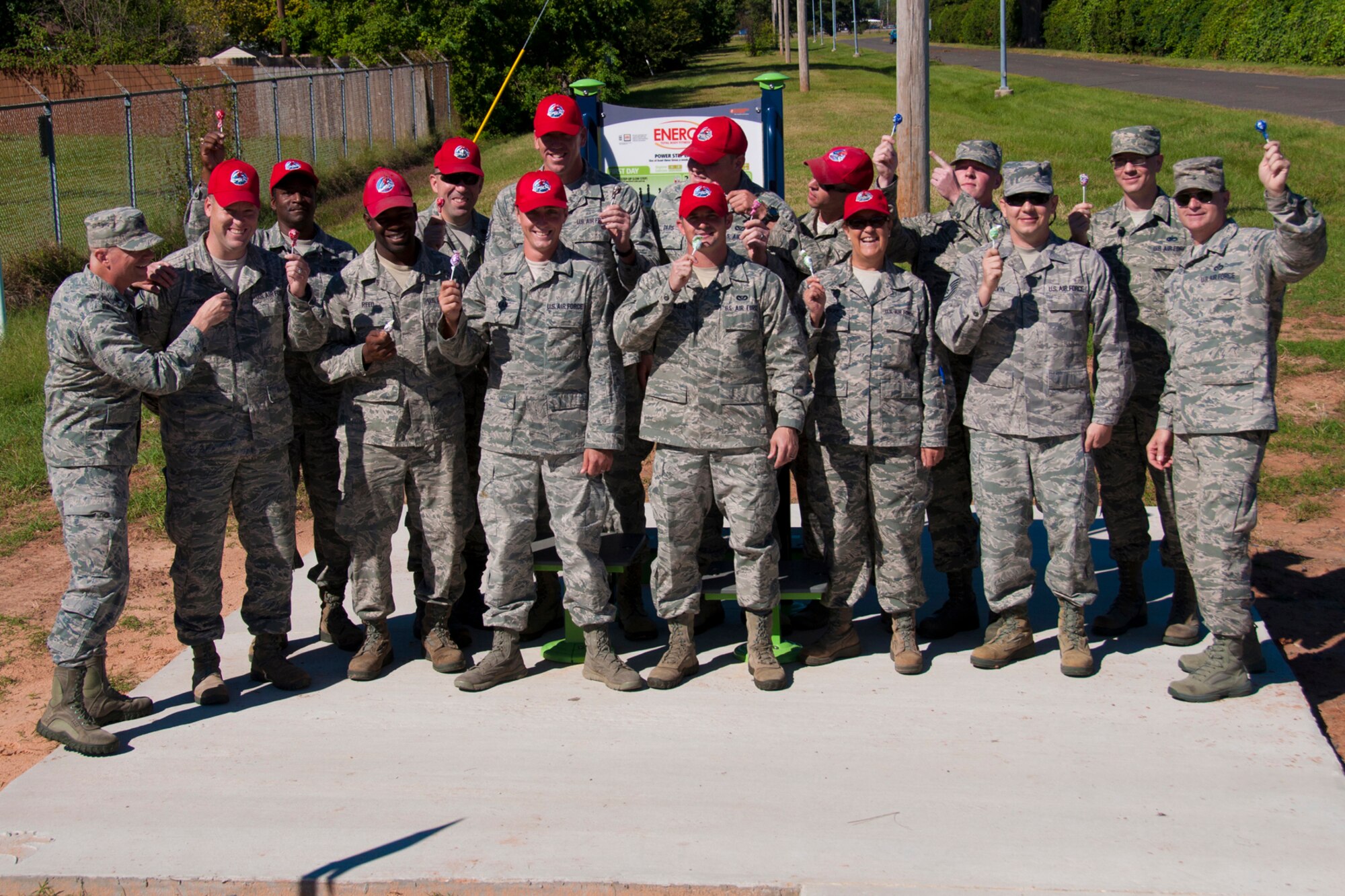 Members of the 307th Bomb Wing and the 307th Rapid Engineer Deployable Heavy Operational Repair Squadron Engineers ham it up with lollipops at the first of several new fitness stations on a running trail at Barksdale Air Force Base, La. Oct. 4, 2014.  Airmen at Barksdale AFB will be able to burn off treats such as these now that they have another cross training alternative in the new exercise equipment.    Members of the 307th Bomb Wing and 2nd Bomb Wing initiated and planned the project with 307th REDHORSE members installing it.  (U.S. Air Force photo by Tech. Sgt. Ted Daigle/released)