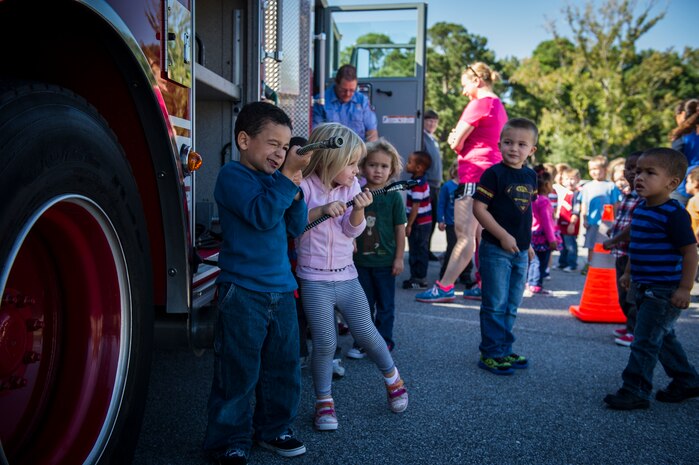 Children from the Brig. Gen. Thomas R. Mikolajcik Child Development Center pretend to put out a fire Oct. 6, 2014, at the CDC parking lot on Joint Base Charleston, S.C. This week was fire prevention week and the JBCHS Fire Department hosted several events throughout the Air Base and Weapons Station. Fire prevention Week was Oct. 5 through 11, and the JB Charleston Fire Department hosted several events around the Air Base and Weapons Station. Fire prevention week was established in 1925 by President Calvin Coolidge when he became aware that close to 15,000 American citizens had been killed in fires the previous year. (U.S. Air Force photo/Airman 1st Class Clayton Cupit)