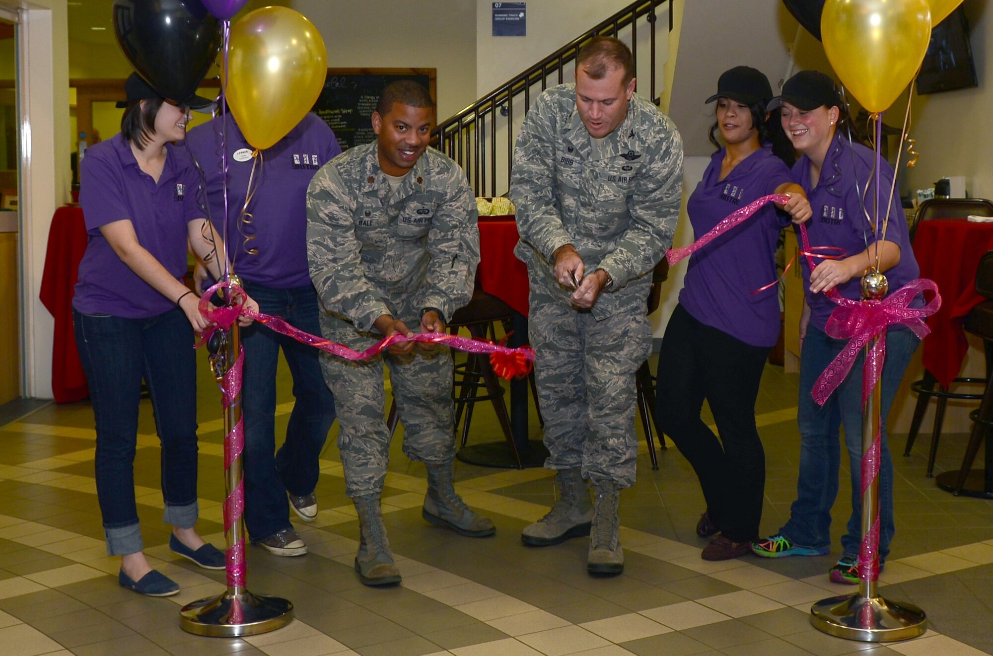 U.S. Air Force Maj. John Ball, third from left, 100th Force Support Squadron commander, and U.S. Air Force Col. Kenneth T. Bibb Jr., third from right, 100th Air Refueling Wing commander, cut a ribbon at the grand opening of the Low Cal Bistro Oct. 9, 2014, at the Hardstand Fitness Center on RAF Mildenhall, England. The Low Cal Bistro will offer healthy food options and beverages to customers at the fitness center. (U.S. Air Force photo/Airman 1st Class Jonathan Light/Released)