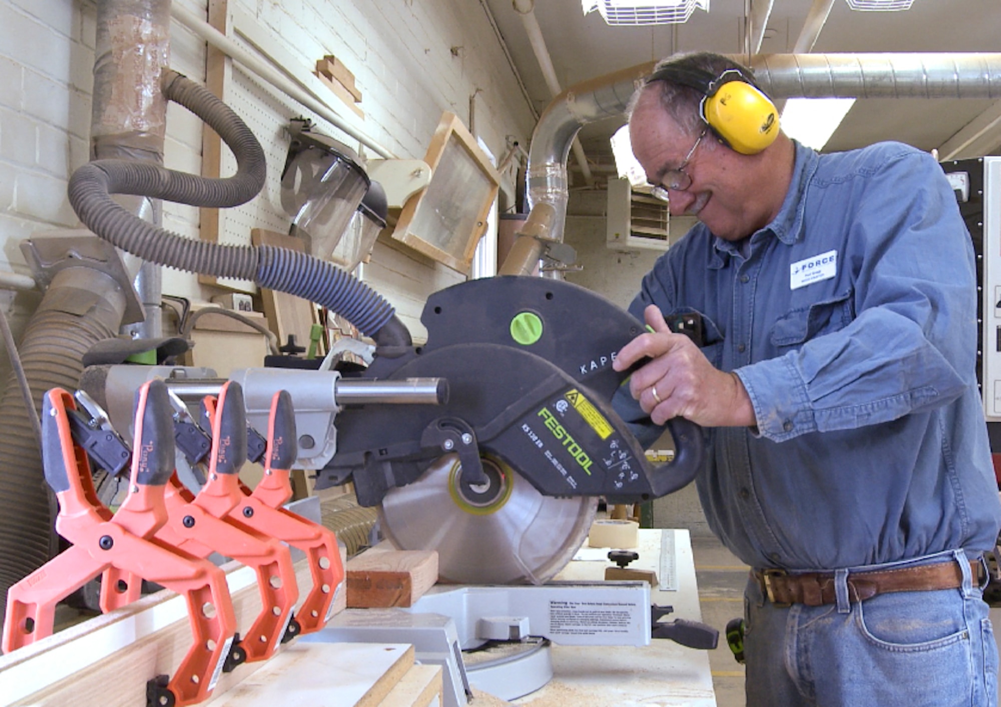 Paul Gregg, 90th Force Support Squadron wood crafter, uses a rotary saw to cut sections from a plank of wood in the F.E. Warren Arts and Crafts Center wood shop Oct. 8, 2014. The shop creates a variety of woodcrafts, which can be seen on display in work centers around the base. (U.S. Air Force photo by Senior Airman Jason Wiese)
