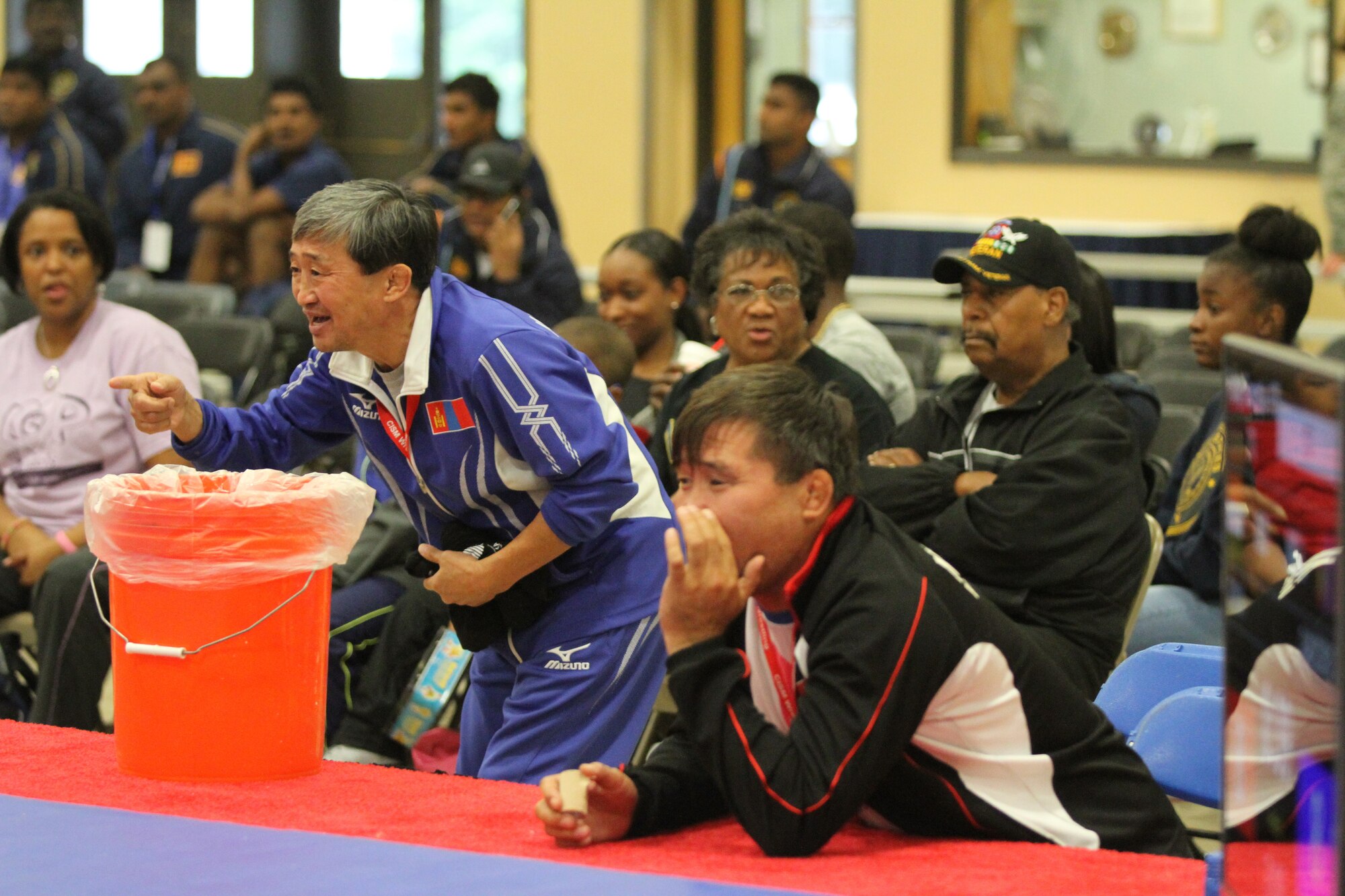 Coaches for the Mongolian competitors shout encouragement to their competitor during the Conseil International Du Sport – International Military Sports Council – World Wrestling Championship held at the Griffith Field House on Joint Base McGuire-Dix-Lakehurst, N.J., Oct. 3, 2014. The CISM is a multinational military sorts organization that aspires to unite competitors, and their nations, through sport. (U.S. Army photo by Sgt. Christopher Moore/Released)