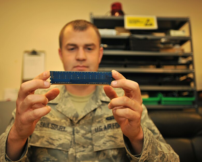 Airman 1st Class Adam Saulsbury, 319th Communications Squadron client system technician, inspects a random access memory chip to put into a desktop computer, on Oct. 8, 2014, on Grand Forks Air Force Base, N.D. Saulsbury was selected as the base's Warrior of the Week for the second week in October 2014. (U.S. Air Force photo/Senior Airman Xavier Navarro)