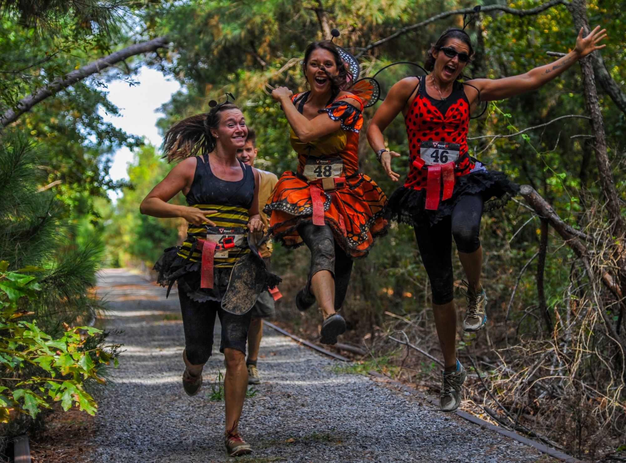A group of runners jumps on their way toward the finish line of the Zombie Resistance Run Oct. 4, 2014, at Little Rock Air Force Base, Ark. The competition is an annual fundraising event held by the 19th Operations Support Squadron Booster Club.  (U.S. Air Force photo by Airman 1st Class Harry Brexel)
