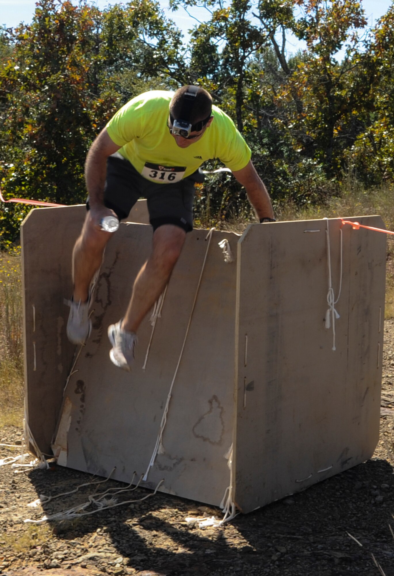 Master Sgt. Michael Hill, 19th Operations Support Squadron air traffic control standards and evaluations noncommisioned officer in charge, jumps over an obstacle in the Zombie Resistance Run Oct. 4, 2014, at Little Rock Air Force Base, Ark. The fundraising event had a series of man-made and natural obstacles for participants to overcome. (U.S. Air Force photo by Airman 1st Class Harry Brexel)
