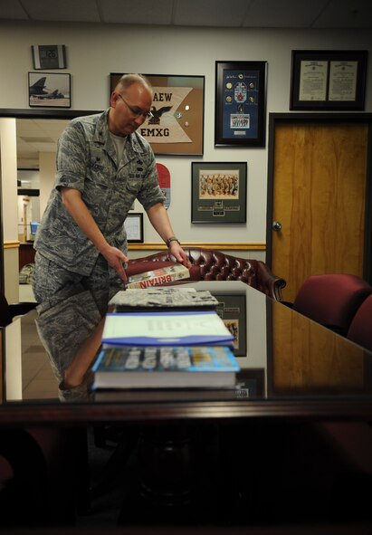 U.S. Air Force Col. Jeffrey Decker, 23d Maintenance Group commander, aligns books on a conference table in his office Sept. 25, 2014, at Moody Air Force Base, Ga. Decker rotates the books every few days highlighting relevant historic and current events. (U.S. Air Force photo by Andrea Jenkins)