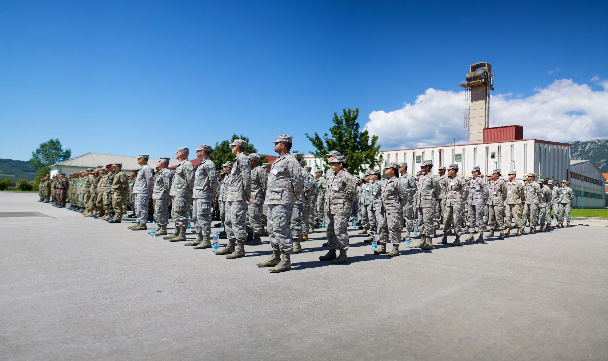 Airmen stand at parade rest for a multi-national formation in preparation for the opening ceremony during Exercise Immediate Response in Slovenia. Exercises like Immediate Response give partner nations the necessary opportunity to learn to train and work together. (U.S. Air Force Photo by Maj. Joshua Young/Released)