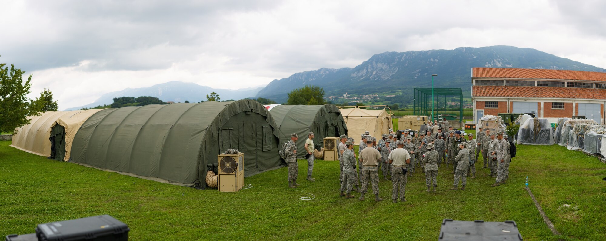 An afternoon huddle takes place after the shelter and tents are assembled during Exercise Immediate Response in Slovenia. The purpose of the two-week exercise was to enhance combat readiness and interoperability between the U.S., Slovenia and partner nations in NATO-led coalition operations. (U.S. Air Force Photo by Maj. Joshua Young/Released)