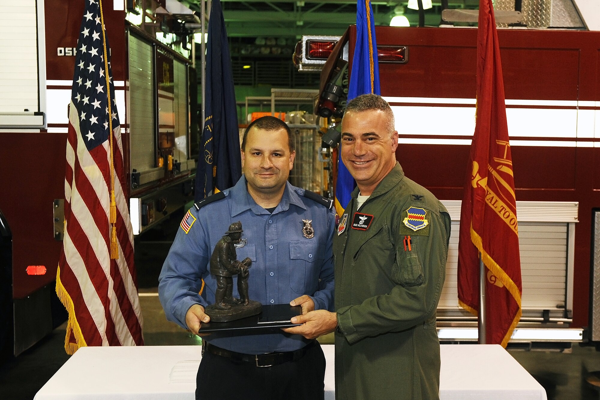 U.S. Air Force Col. Mark L. Williamson, 55th Wing vice commander, presents the Firefighter of the Year award to David Yelovich, 55th Civil Engineer Squadron firefighter, Oct. 9 during a ceremony held in the Offutt Air Force Base Fire Station.  Offutt annually recognizes one of their firefighters in conjunction with the National Fire Prevention Week.  (U.S. Air Force photo by Josh Plueger/Released)