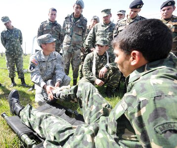 Uruguayan soldiers demonstrate how to splint a fracture on U.S. Navy Senior Chief Petty Officer Fernando Gonzalez, assigned to the Navy Medicine Training Support Center based at Joint Base San Antonio-Fort Sam Houston, during a tactical combat lifesaver course subject matter expert exchange Sept. 16 in Toledo, Uruguay.

Photo by Robert R. Ramon
