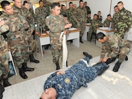 Uruguayan soldiers demonstrate how to splint a fracture on U.S. Navy Senior Chief Petty Officer Fernando Gonzalez, assigned to the Navy Medicine Training Support Center based at Joint Base San Antonio-Fort Sam Houston, during a tactical combat lifesaver course subject matter expert exchange Sept. 16 in Toledo, Uruguay.