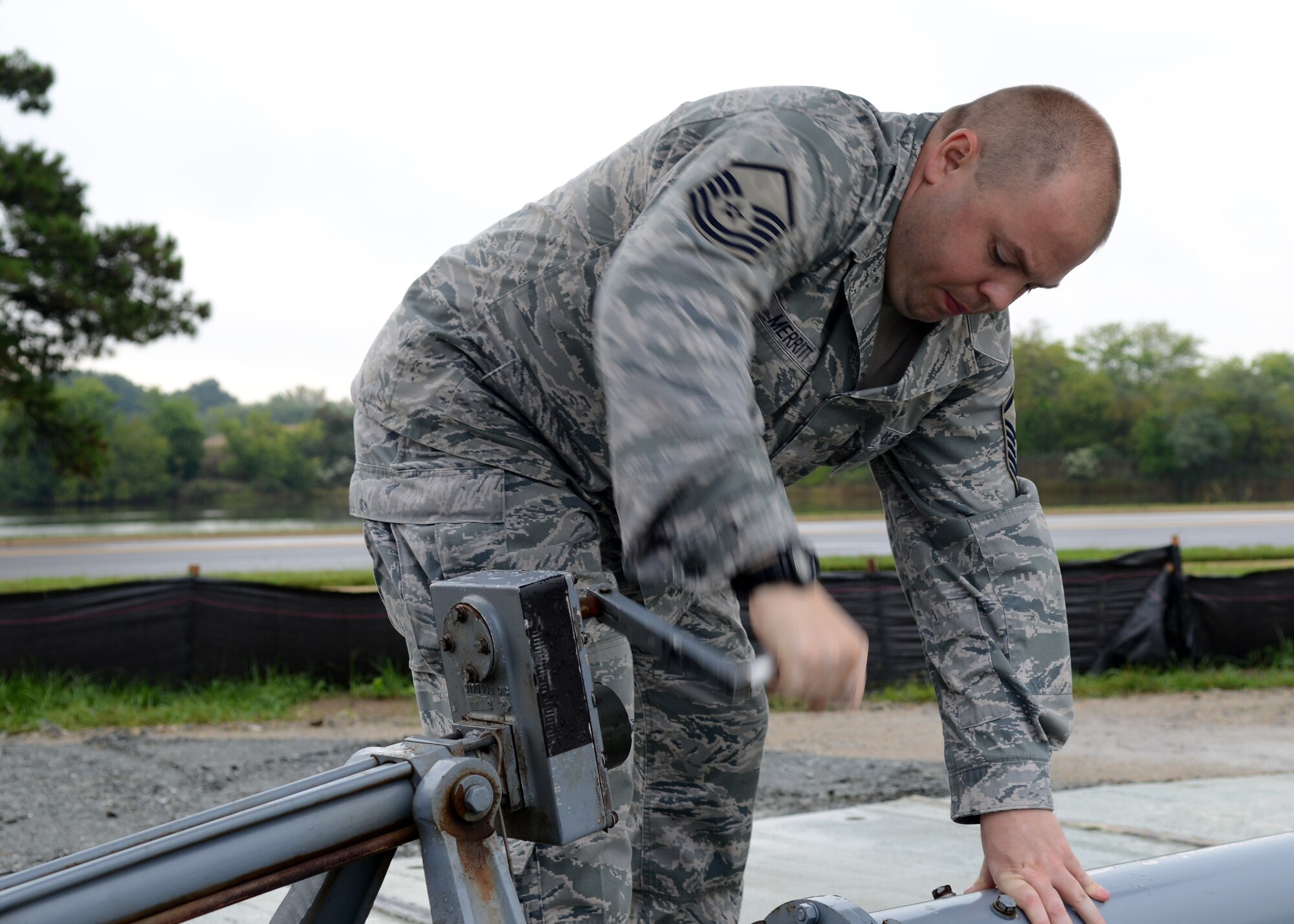 U.S. Air Force Master Sgt. Danny Merritt, 1st Maintenance Group crash recovery team chief, raises the hydraulic stand to temporarily hold an F-15 Eagle static display at Langley Air Force Base, Va., Oct. 4, 2014. The Eagle on display was the first F-15 to arrive at Langley Air Force Base in 1975. (U.S. Air Force photo by Airman 1st Class Devin Scott Michaels/Released)