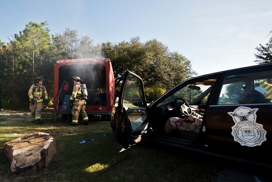 North Bay firefighters evaluate the accident scene during a major accident response exercise Oct. 7 at Eglin Air Force Base, Fla.  The exercise scenario was a simulated vehicle-borne improvised explosive device was detonated at the explosive ordnance disposal school house killing and injuring students. The exercise helped train Navy EOD School staff, Team Eglin first responders and local emergency crews.  Firefighters and emergency medical technicians responded to the scene to put out the fire and assist the victims.  (U.S. Air Force photo/Samuel King Jr.)