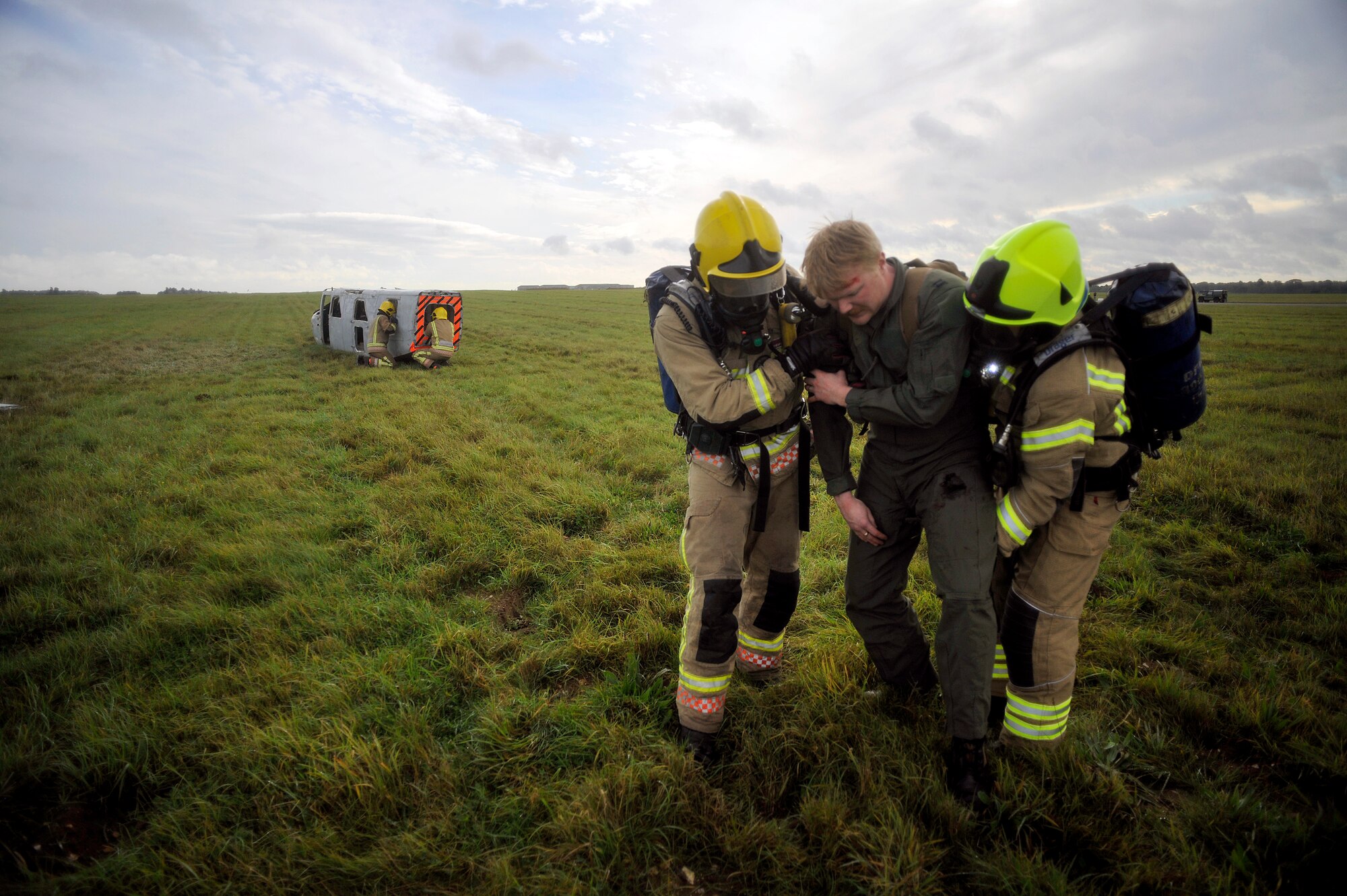 Firefighters from Suffolk Fire and Rescue Service move simulated patient Jeremy Kossbiel, 48th Medical Group education and training contractor from Erie, Pa., to safety during a Major Accident Response Exercise Oct. 7, 2014, on RAF Honington, England. The purpose of the MARE was to test the response actions of RAF Mildenhall, RAF Honington and local first responders. (U.S. Air Force photo/Senior Airman Christine Griffiths/Released)