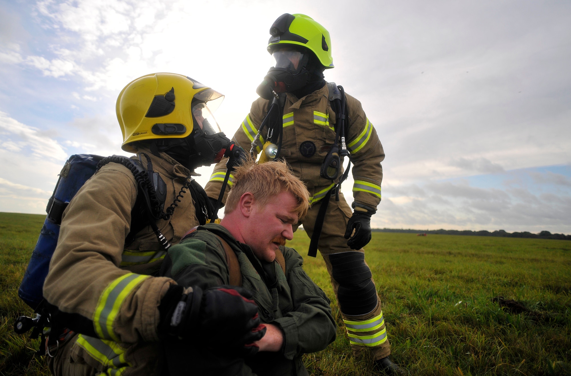 Firefighters from Suffolk Fire and Rescue Service discuss how to carry simulated patient Jeremy Kossbiel, 48th Medical Group education and training contractor from Erie, Pa., to safety during a Major Accident Response Exercise Oct. 7, 2014, on RAF Honington, England. The purpose of the MARE was to test the response actions of RAF Mildenhall, RAF Honington and local first responders. (U.S. Air Force photo/Senior Airman Christine Griffiths/Released)
