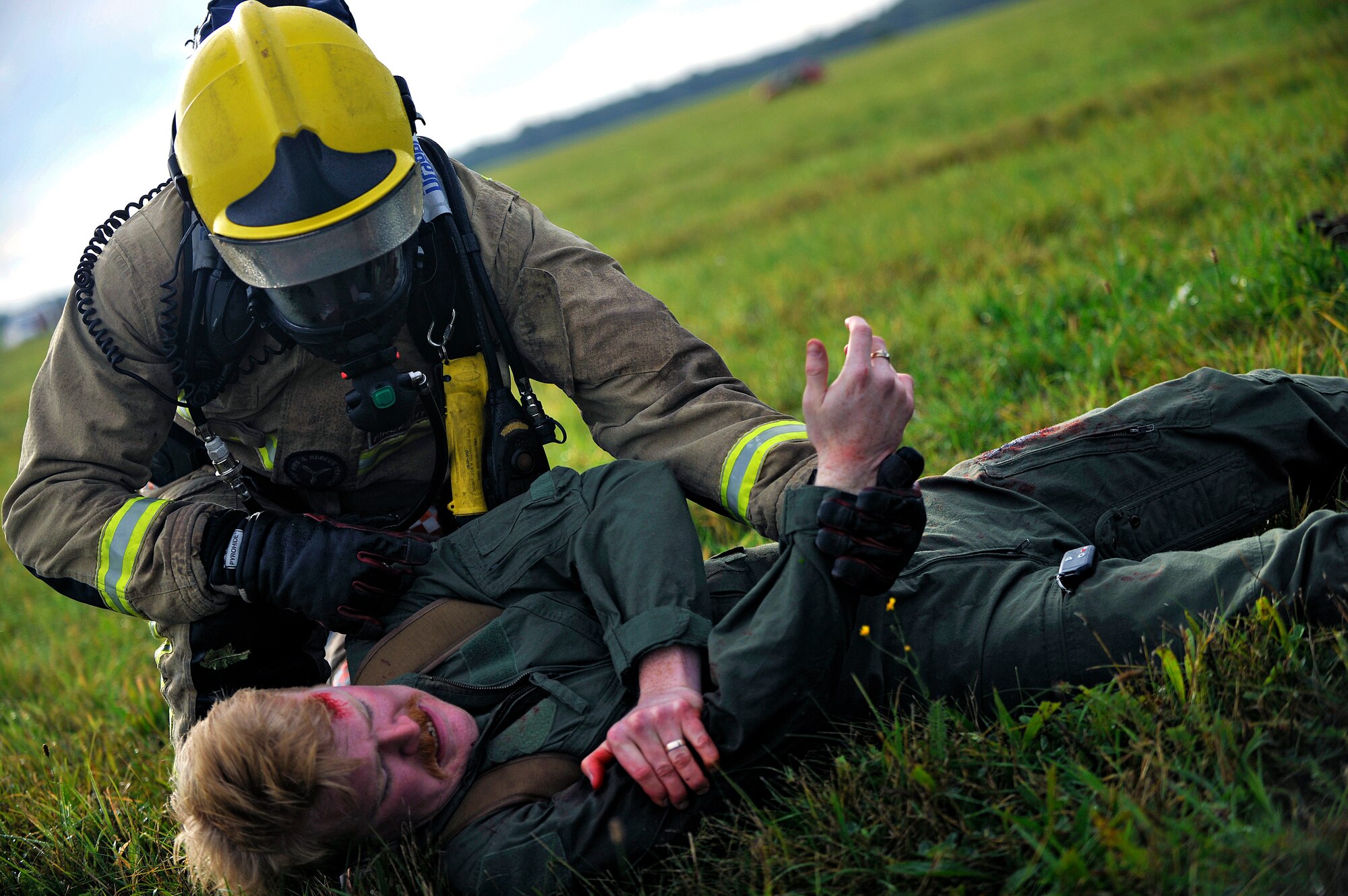 A firefighter from Suffolk Fire and Rescue Service attempts to keep simulated patient Jeremy Kossbiel, 48th Medical Group education and training contractor from Erie, Pa., calm during a Major Accident Response Exercise Oct. 7, 2014, on RAF Honington, England. The purpose of the MARE was to test the response actions of RAF Mildenhall, RAF Honington and local first responders. (U.S. Air Force photo/Senior Airman Christine Griffiths/Released) 
