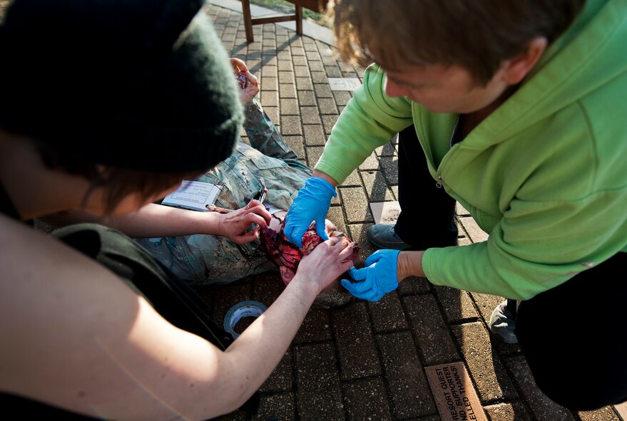 Team Eglin’s moulage team members apply last minute touches to a student’s simulated protruding eyeball prior to a major accident response exercise Oct. 7 at Eglin Air Force Base, Fla.  The exercise scenario was a simulated vehicle-borne improvised explosive device was detonated at the EOD school house killing and injuring students. The moulage team created simulated cuts, burns and bone breaks on approximately 15 students to provide realism for the medical and firefighting teams.  The exercise helped train Navy EOD School staff, Team Eglin first responders and local emergency crews.  Firefighters and emergency medical technicians responded to the scene to put out the fire and assist the victims.  (U.S. Air Force photo/Samuel King Jr.)