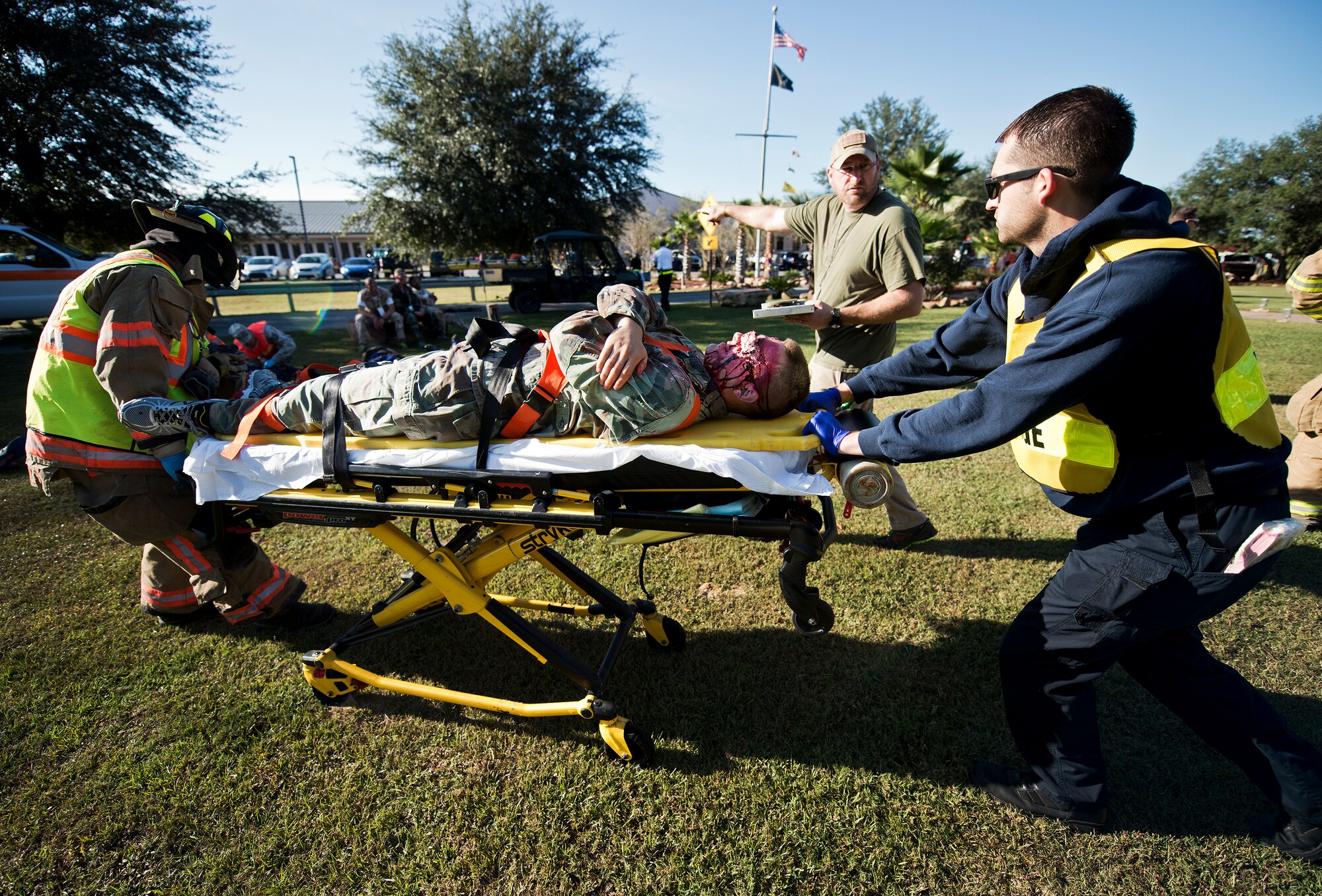 Base and local first responders work with Navy School Explosive Ordnance Disposal personnel to move a simulated victim to the triage area during a major accident response exercise Oct. 7 at Eglin Air Force Base, Fla.  The exercise scenario was a simulated vehicle-borne improvised explosive device was detonated at the explosive ordnance disposal school house killing and injuring students. The exercise helped train Navy EOD School staff, Team Eglin first responders and local emergency crews.  Firefighters and emergency medical technicians responded to the scene to put out the fire and assist the victims.  (U.S. Air Force photo/Samuel King Jr.)