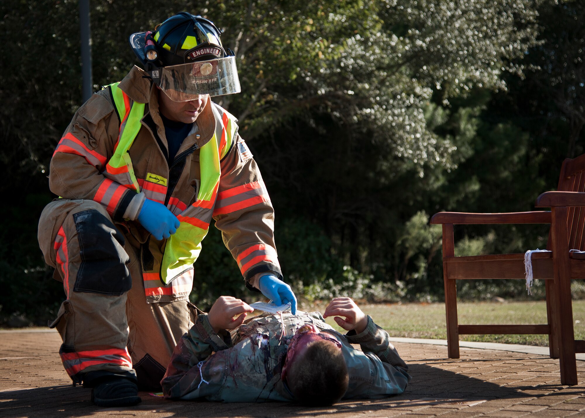 A 96th Test Wing firefighter examines a simulated victim during a major accident response exercise Oct. 7 at Eglin Air Force Base, Fla.  The exercise scenario was a simulated vehicle-borne improvised explosive device was detonated at the explosive ordnance disposal school house killing and injuring students. The exercise helped train Navy EOD School staff, Team Eglin first responders and local emergency crews.  Firefighters and emergency medical technicians responded to the scene to put out the fire and assist the victims.  (U.S. Air Force photo/Samuel King Jr.)