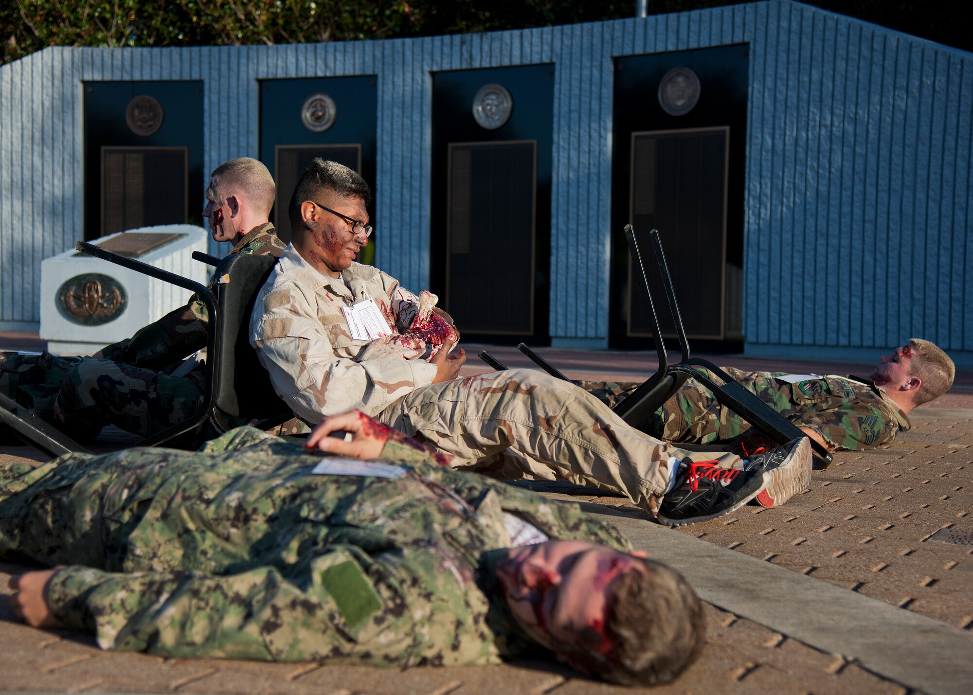 Injured students lie in front of the Explosive Ordnance Disposal Memorial after a simulated vehicle-borne improvised explosive device was detonated at the EOD school house Oct. 7 at Eglin Air Force Base, Fla.  The scene was part of a major accident response exercise for the Navy EOD School, Team Eglin first responders and local emergency crews.  Firefighters and emergency medical technicians responded to the scene to put out the fire and assist the victims.  (U.S. Air Force photo/Samuel King Jr.)
