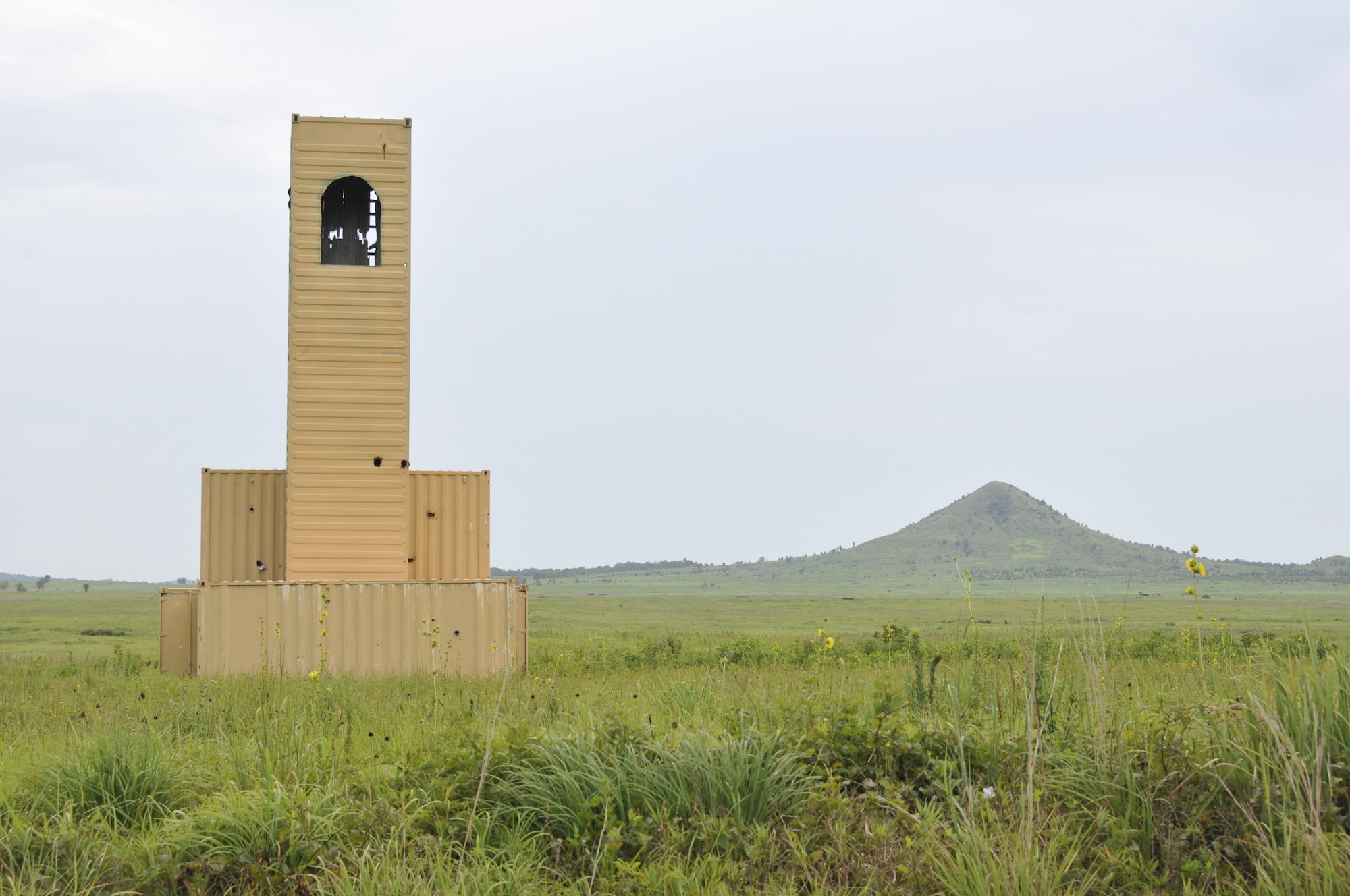 A building used as a simulated target stands with Potato Hill in the background at 188th Wing Detachment 1 Razorback Range at Fort Chaffee Maneuver Training Center, Arkansas, July 14, 2014. The range is maintained by the 188th and provides varying types of training to military units from around the world. (U.S. Air National Guard photo by Staff Sgt. John Suleski/released)